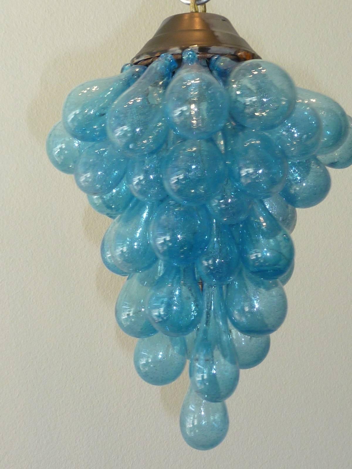 A vintage Italian Murano glass chandelier in the motif of a grape cluster. Mouth blown glass drops in nice blue color on a metal frame and illuminated from one Edison lightbulb. Working condition, ready to hang.