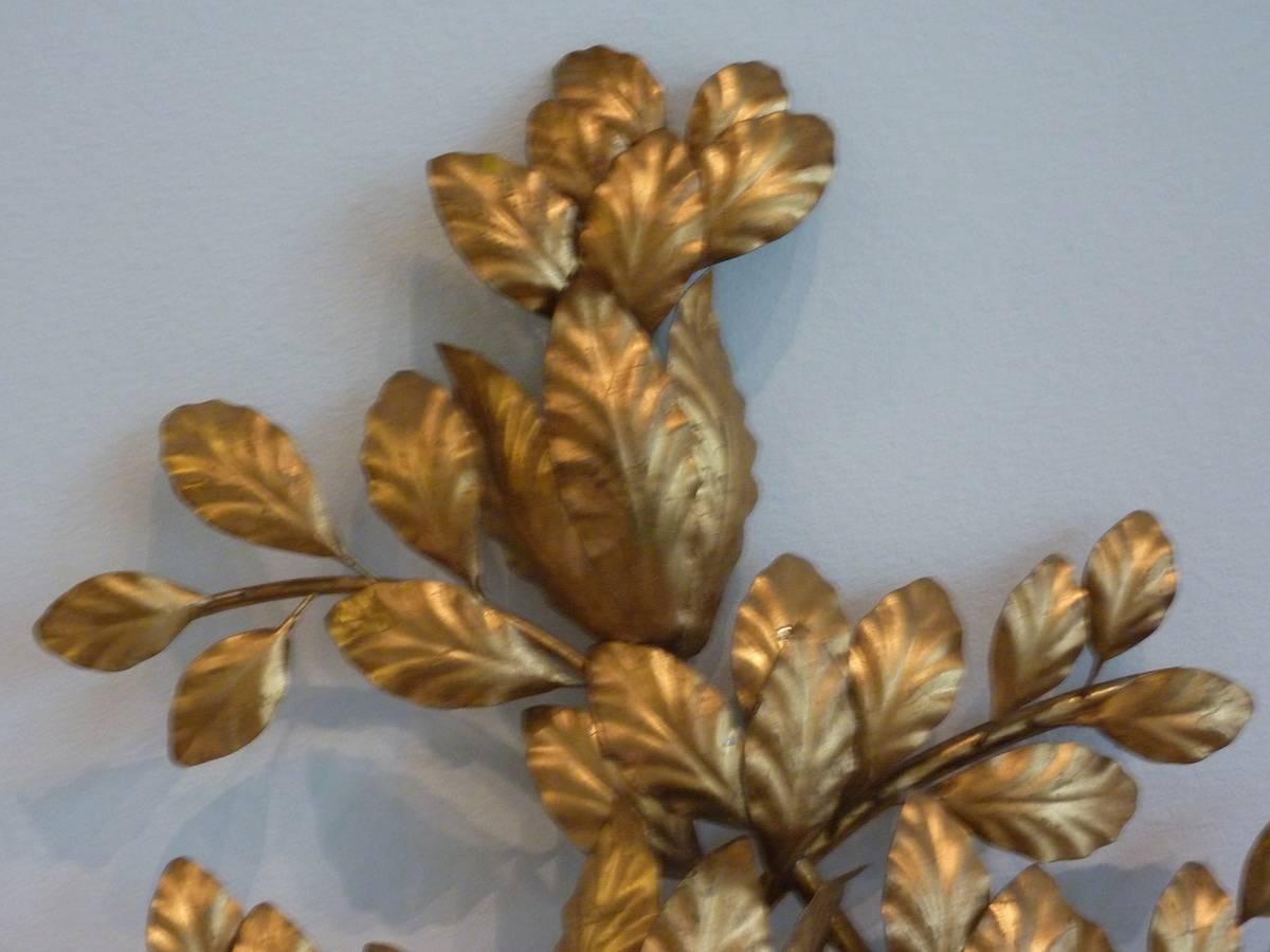 A Mid-Century Italian three light wall sconce of gilded metal in the form of leaves, in the Hollywood Regency style. The fixture has original European wiring and can be used with E14 110 Volt Bulbs or Adapters. Marked Italy.