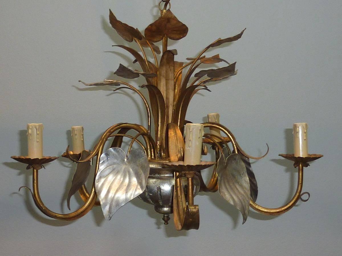 This Italian floral tole chandelier is beautiful and very special. Made of wood and metal in silver and gold paint. The chandelier is in working condition. Note that the chandelier works with five European E14 110 volt bulbs. No bulbs included. The