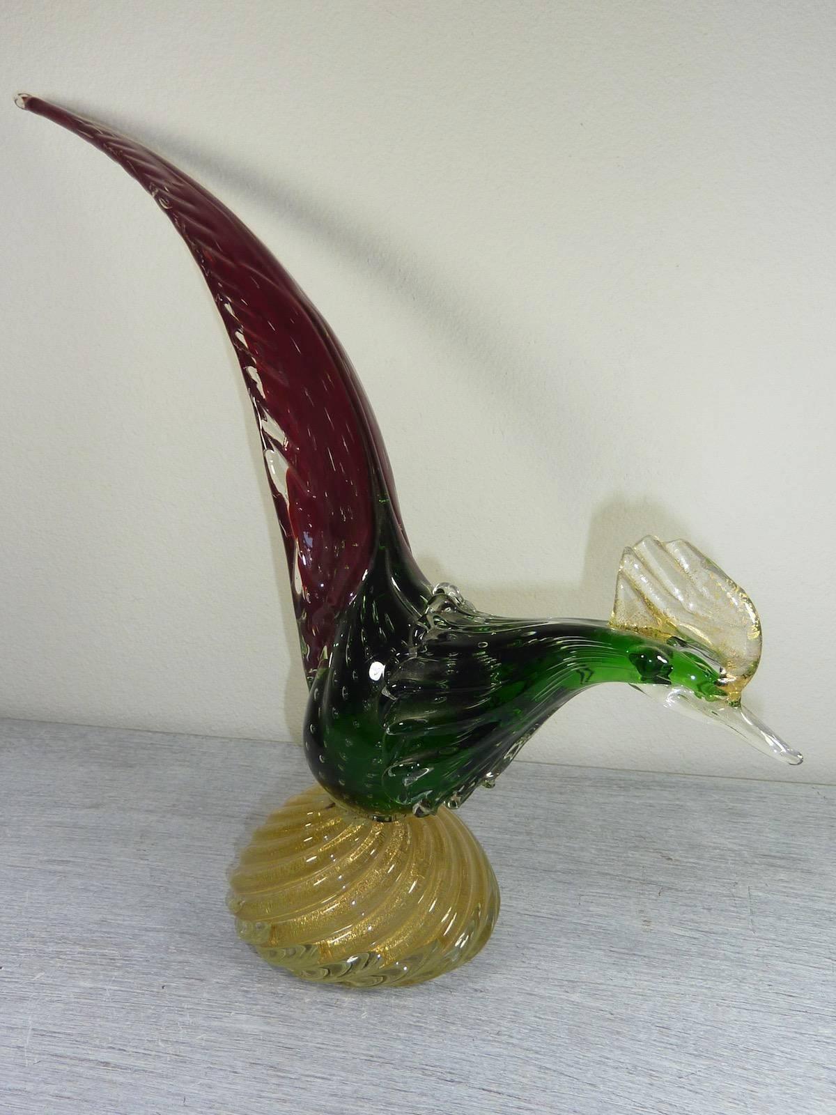 A Venetian sculptural pheasant in handblown glass, produced on the isle of Murano, circa 1950s. The bird comes in red, green and clear glass and gadrooned base decorated with flecks of gold leaf. Markings include original sticker, indicative of