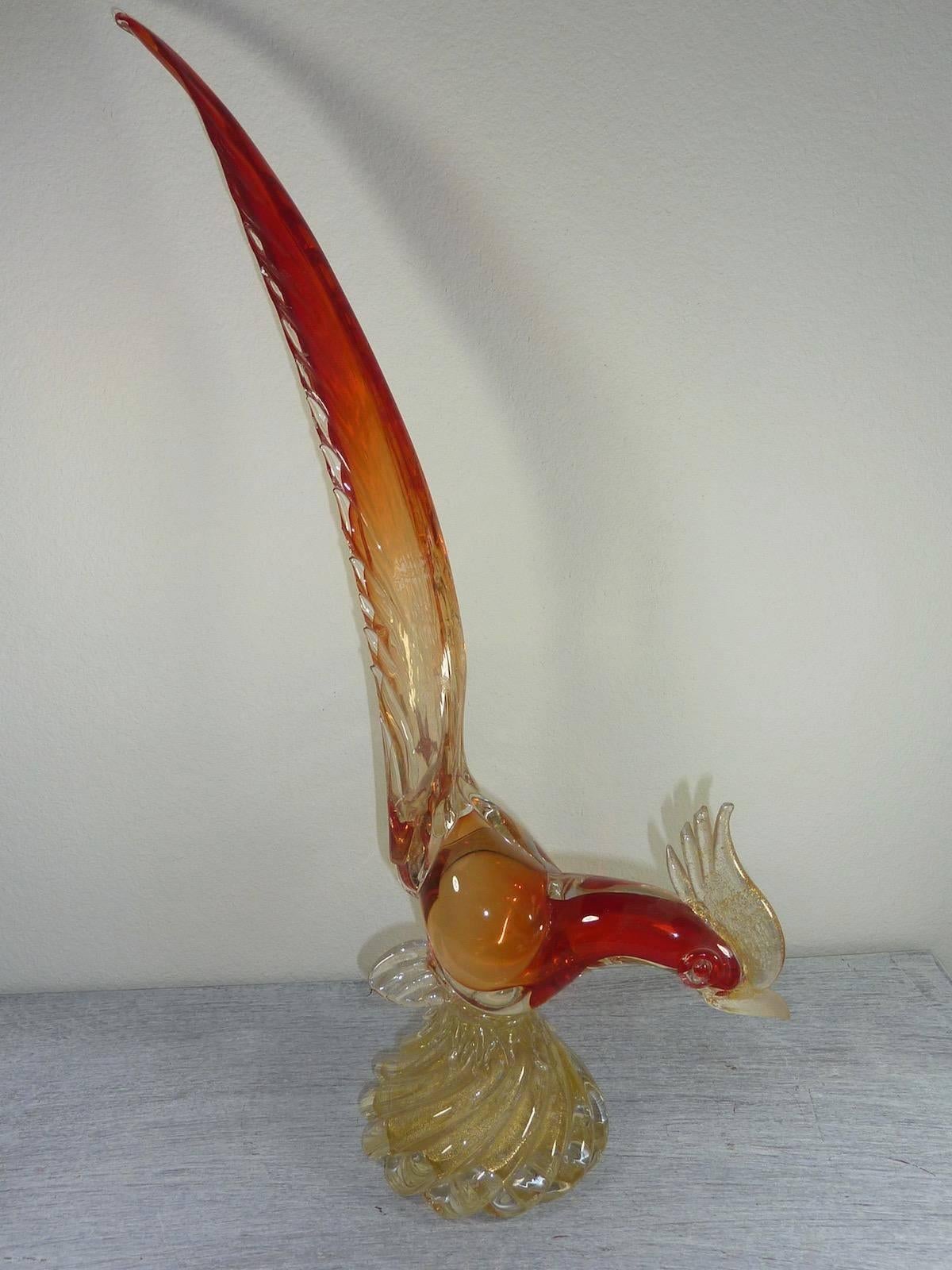 Beautiful handblown Murano glass bird. Made of multiple colors including red, orange, and clear glass. With golden flakes inside. Made on the Isle of Murano in Venice, Italy.
