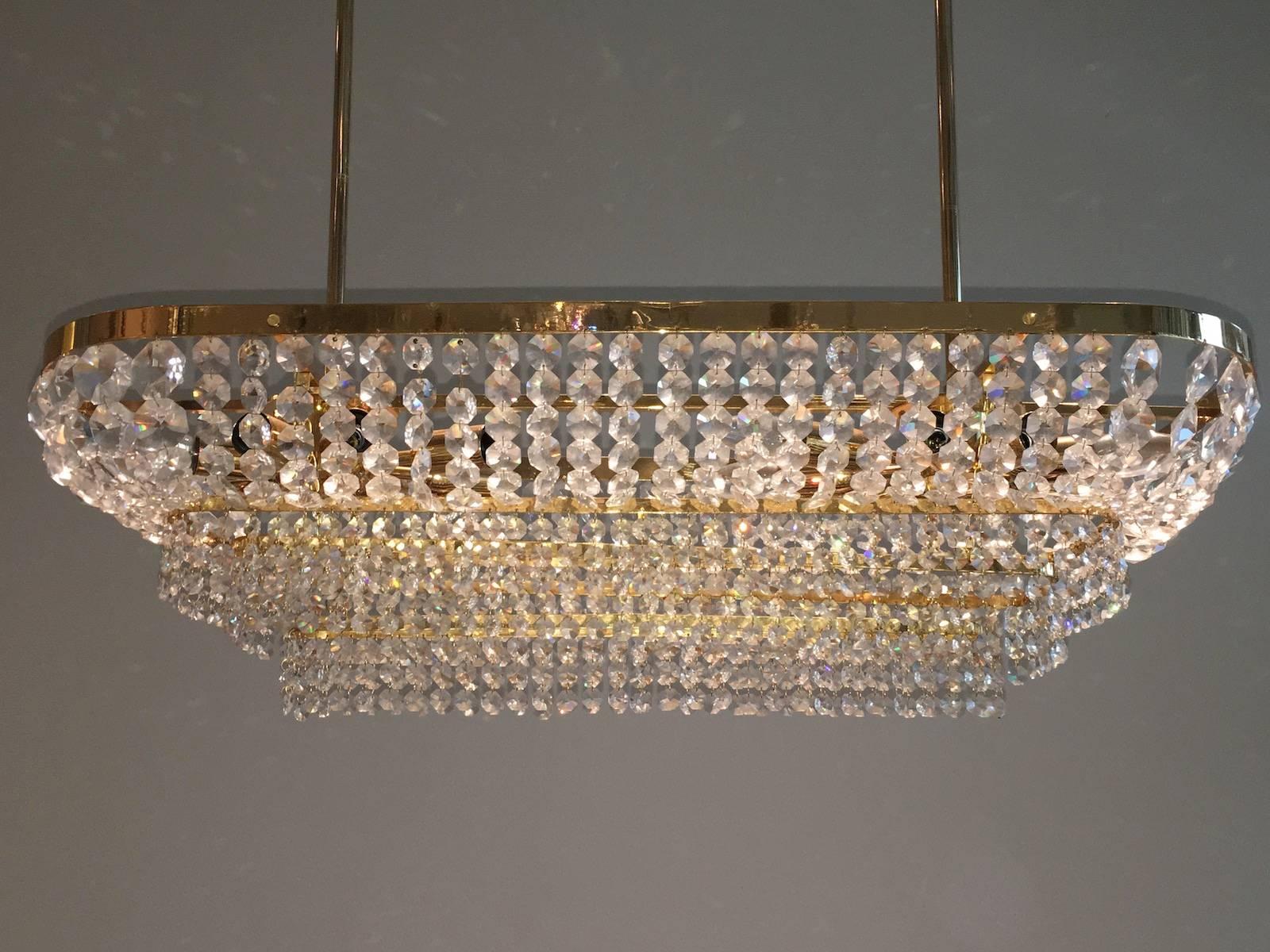 A beautiful handcrafted chandelier, manufactured in the 1970s by Palwa Germany. Made of gold-plated brass with faceted crystal glass prisms. Fixture requires 16 European E14 candelabra bulbs each up to 40 watt. An absolutely stunning piece of