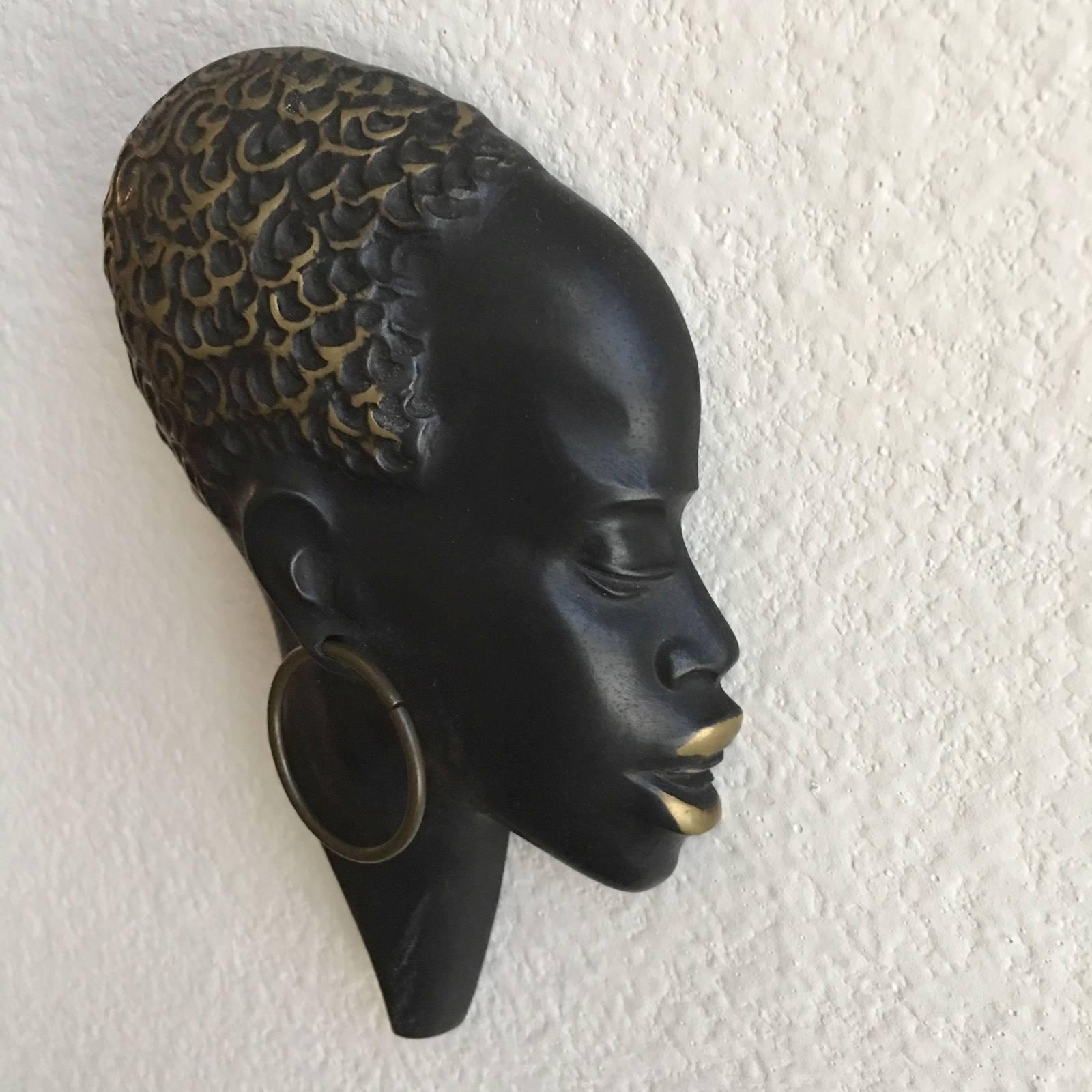A beautiful modernist brass head of an African woman in the style of Werkstatte Hagenauer. Made in Austria in the 1950s. In very good condition with charming patina. Beautiful Wall Decoration piece. Free shipping in the USA.