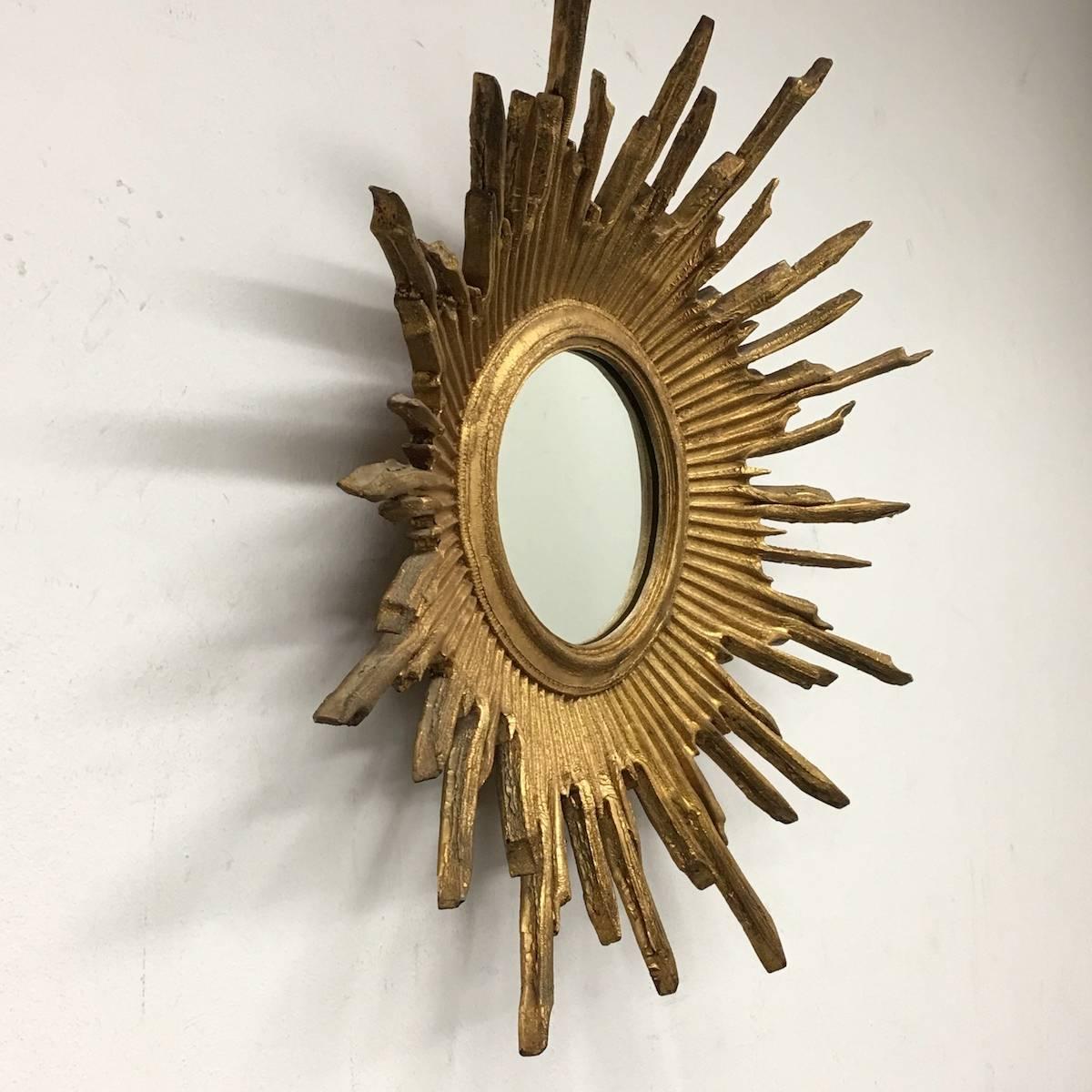 Gorgeous starburst mirror. 
Made of gilded Resin.
No chips, no cracks, no repairs.
Probably little dusty, but this is old-age.
It measures approximate 24 1/2"; in diameter,
Mirror only is approximate 7"; in diameter.
It stands