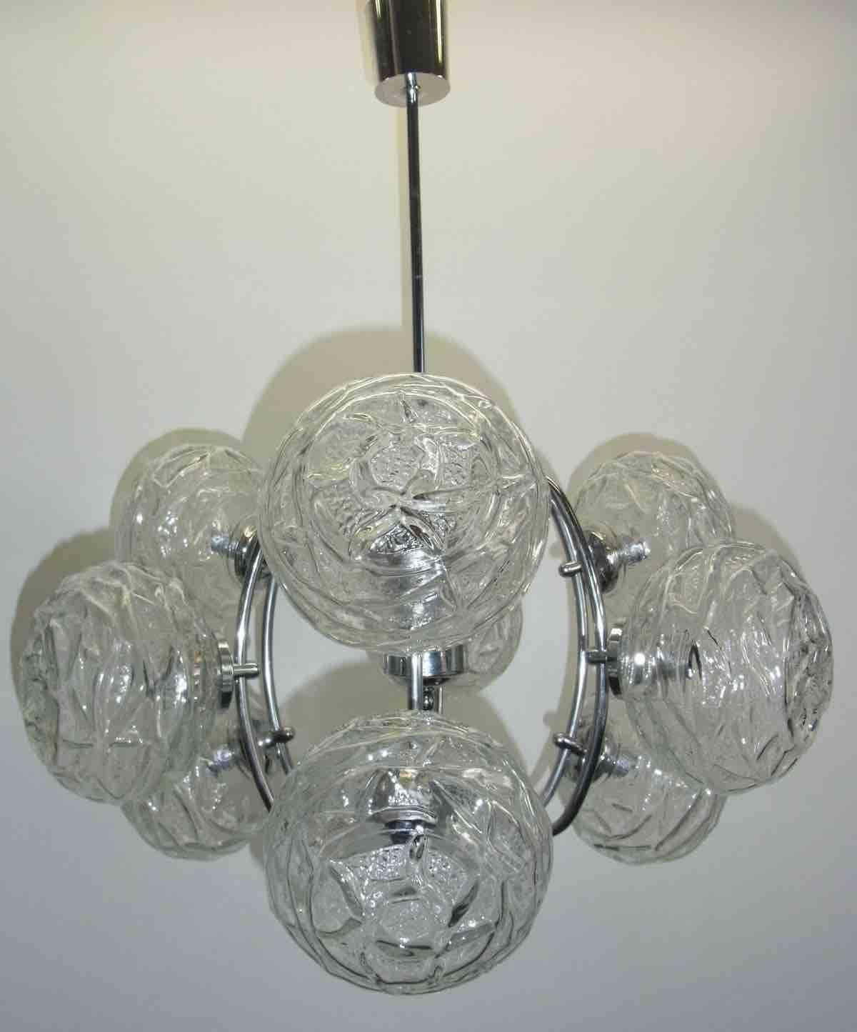 This Mid-Century Modern chandelier was made in the 1960s in Germany. It is made of nine unique glass balls. Made by Honsel Leuchten Germany, marked with Label. The fixture requires nine European E14 candelabra bulbs, each bulb up to 40 watts.