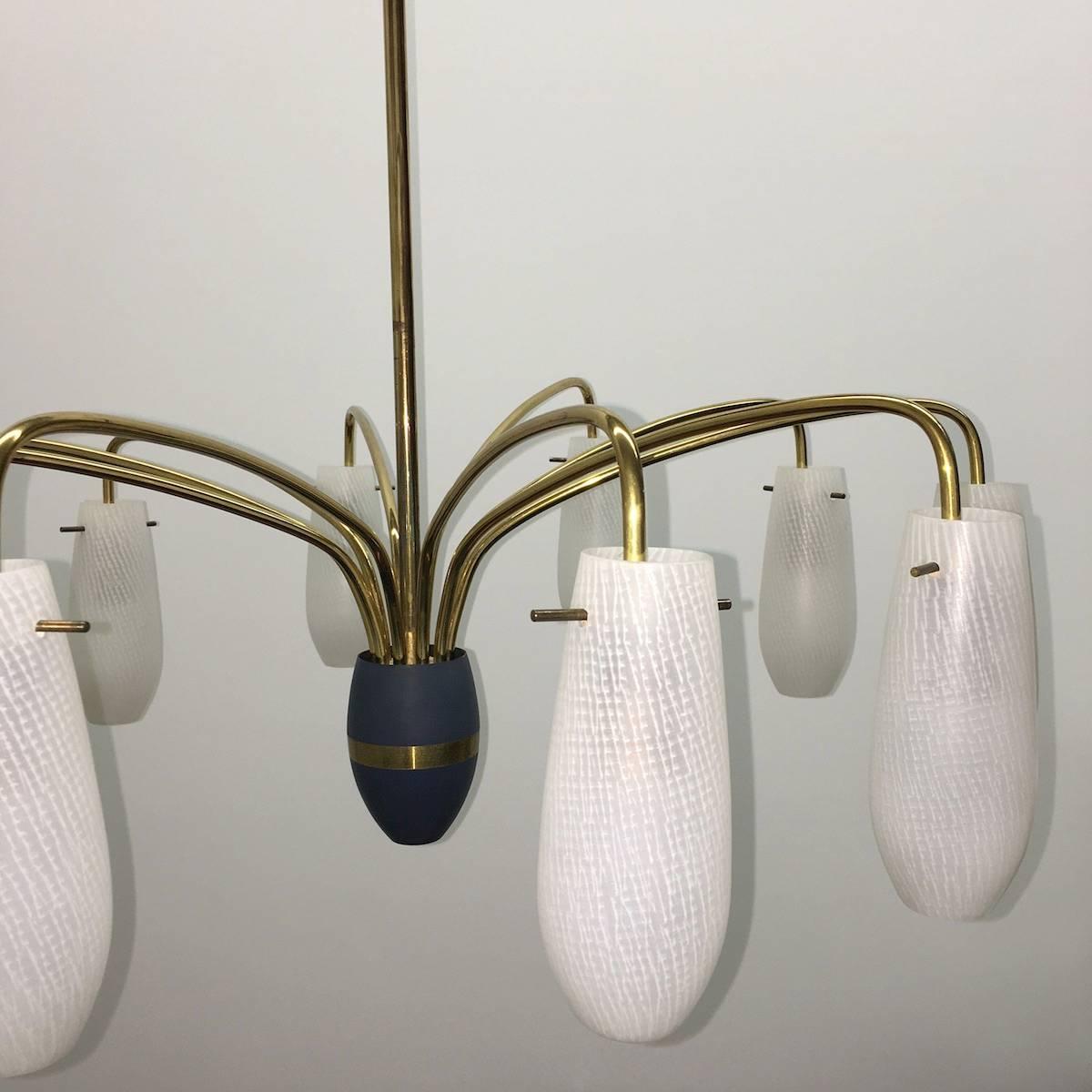 A brass ten arm chandelier ending with glass shades and blue enameled center. Each arm requires one European E14 candelabra bulb, each bulb up to 40 watts.
Note: One glass with a tiny little crack, but not visible when lamp is displayed. See