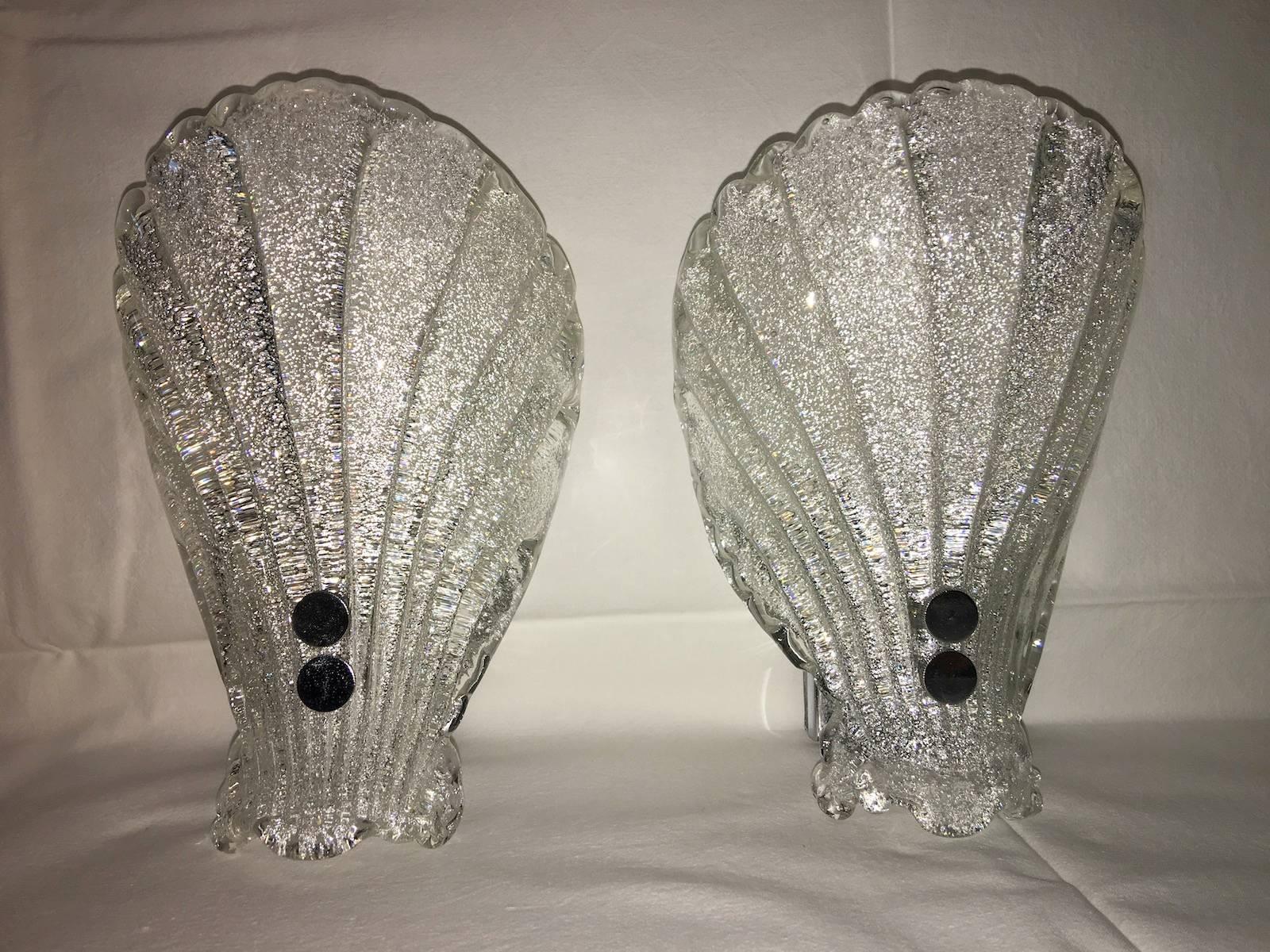 Pair of sconces with ribbed Murano glass shades.
With the 1960's came the accentuated use of glass elements and vintage Italian lights manufacturing companies like Venini and Mazzega who had a strong influence on the modernization of lighting design
