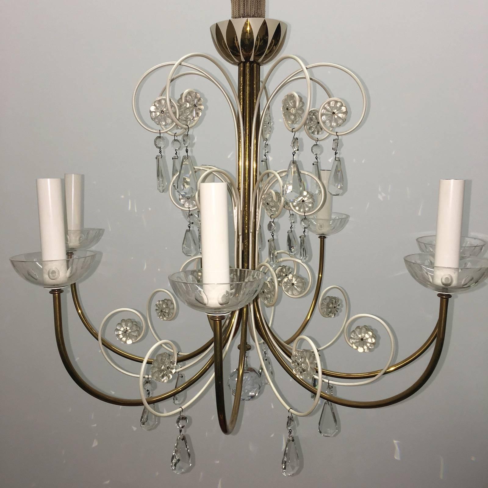 A beautiful chandelier in the form of a fountain. Attributed to Emil Stejnar for Rupert Nikoll, Vienna, Austria. An original vintage piece manufactured in Mid-Century (1950s-1960s). It is made of brass, white enameled Metal and hand-cut crystals. It