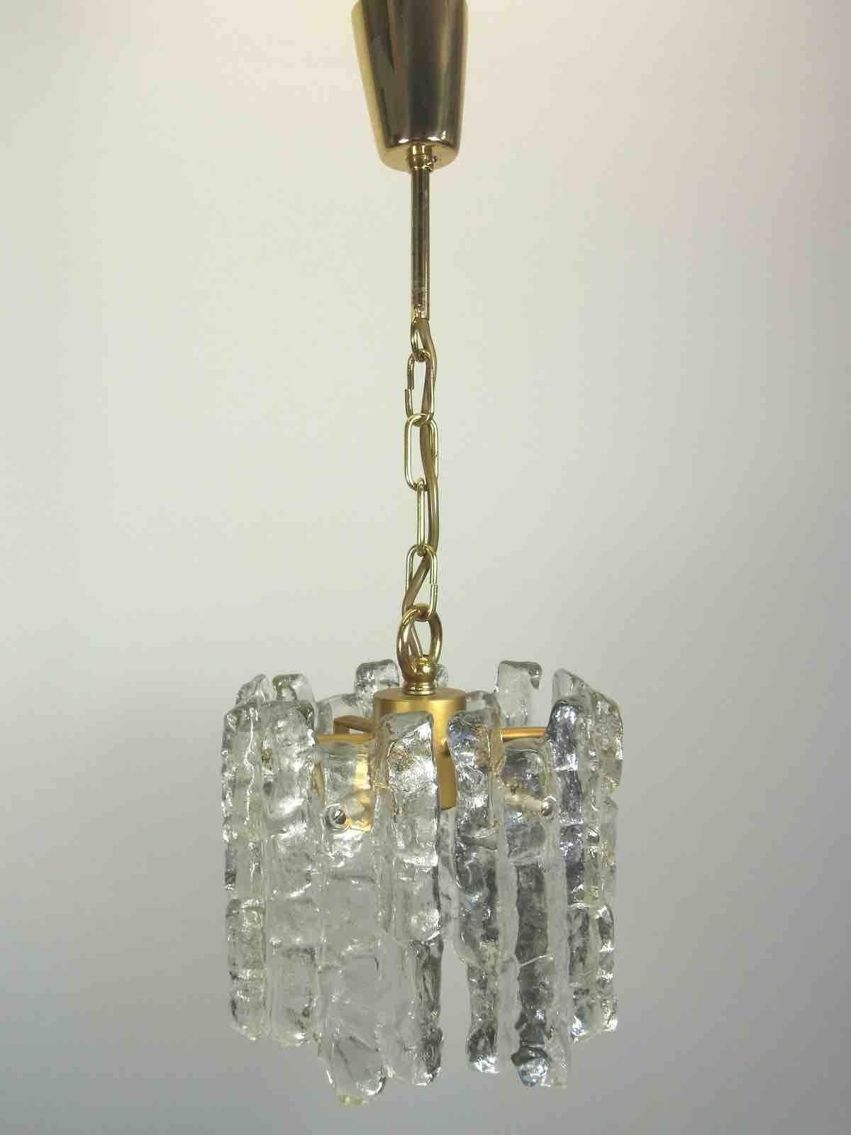 Beautiful pendant light, manufactured by Kalmar Austria in the 1960s. Brass hardware with one light source and six ice glass panels on it. In very good condition. The Fixture requires one European E27 Edison bulb, up to 100 watt.