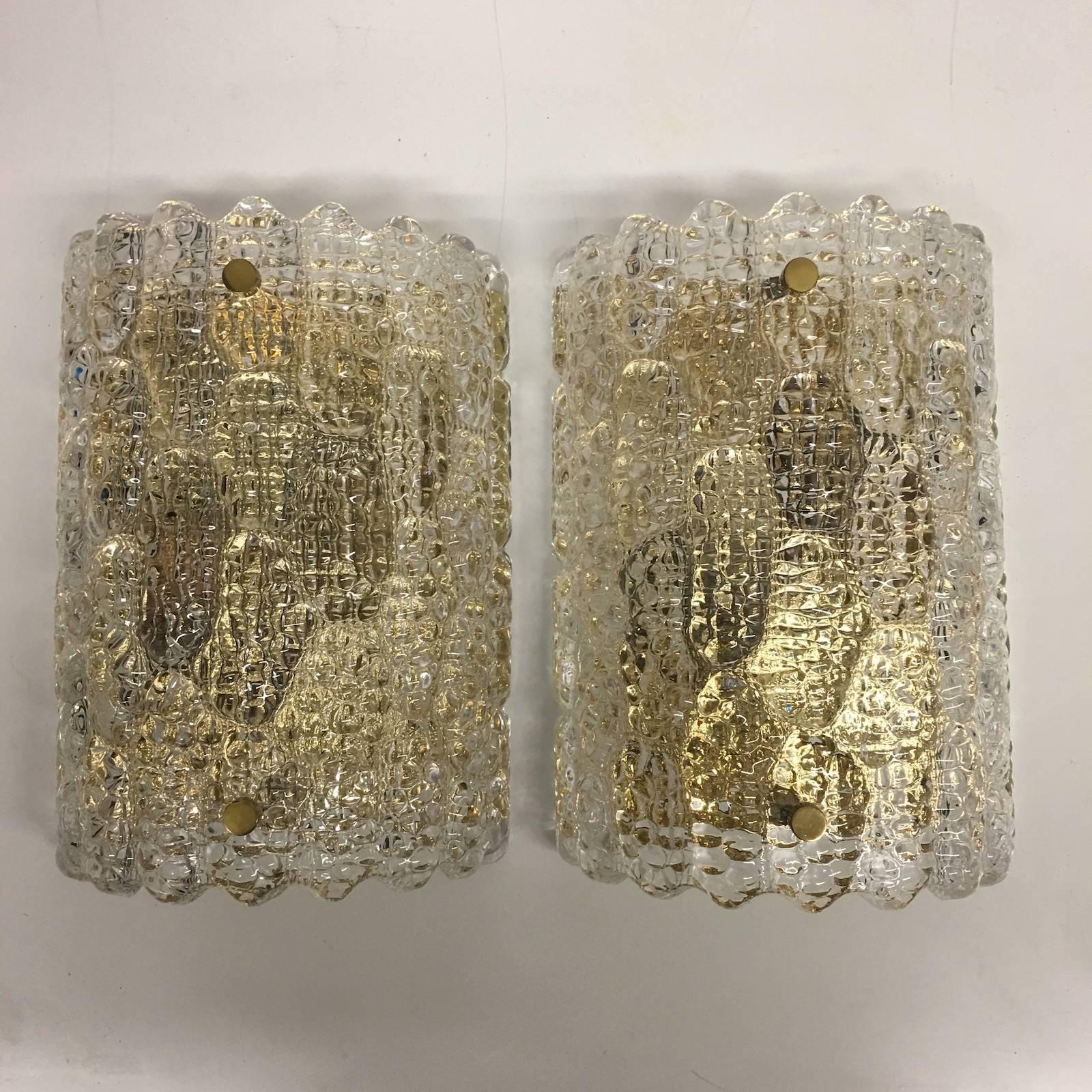 Beautiful sought after Lot of wall sconces by Carl Fagerlund for Orrefors. Pressed textured glass with brass accents mounted on brass wall plates. Each Fixture requires two European E 14 candelabra bulbs, each up to 60 watts. Classy and beautiful