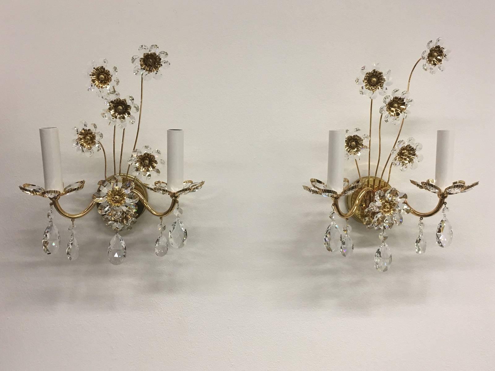Pair of vintage gold-plated sconces with faceted crystal flowers made by the German company Palwa. Each fixture has two European style E14 sockets. It requires two European E14 candelabra bulbs.
