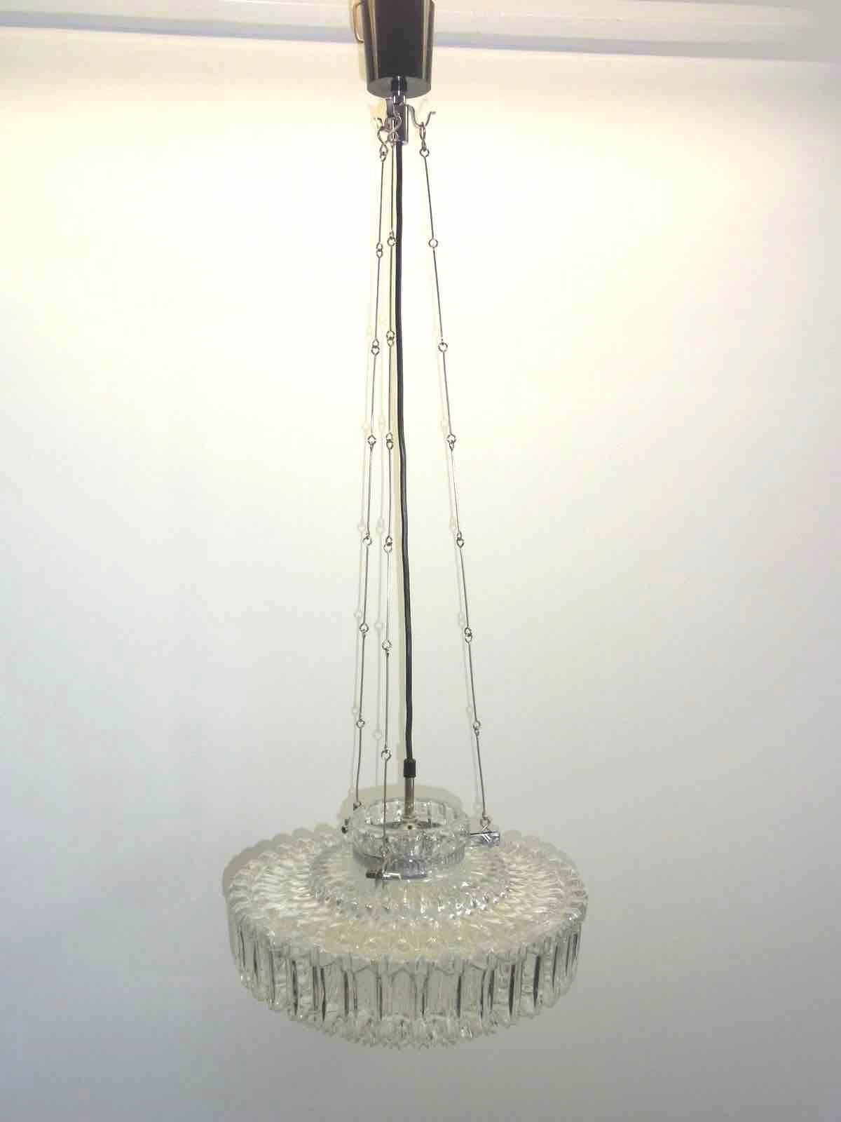 This petite chandelier was produced in the 1960s by Doria Leuchten in Germany. The piece is finished in chrome and requires one Edison bulb with up to 100 Watt. Glass is very heavy depression glass.