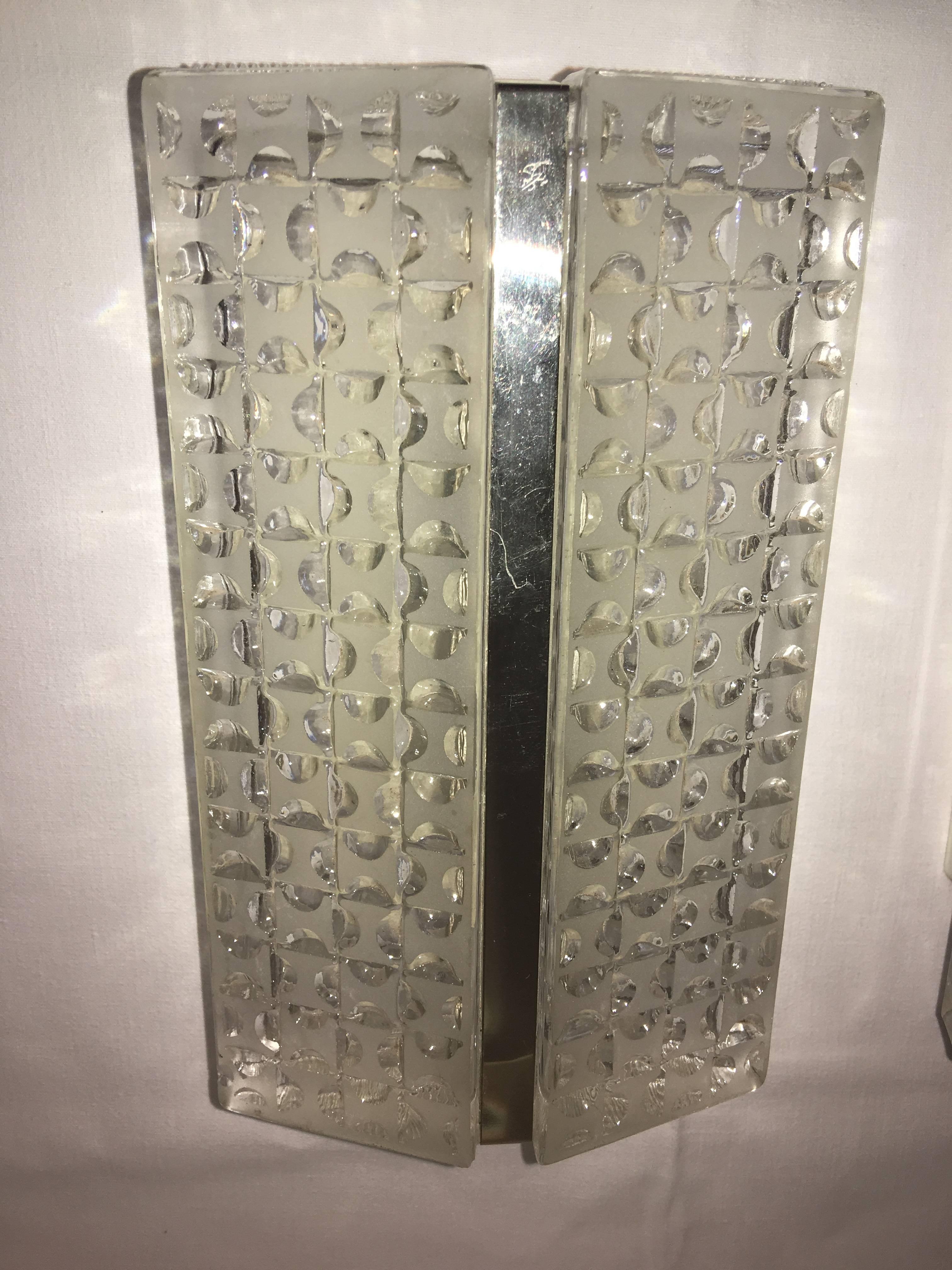 A pair of textured glass sconces with a chrome strip in the middle. Each fixture requires one European E14 candelabra bulb, each bulb up to 40 watts.