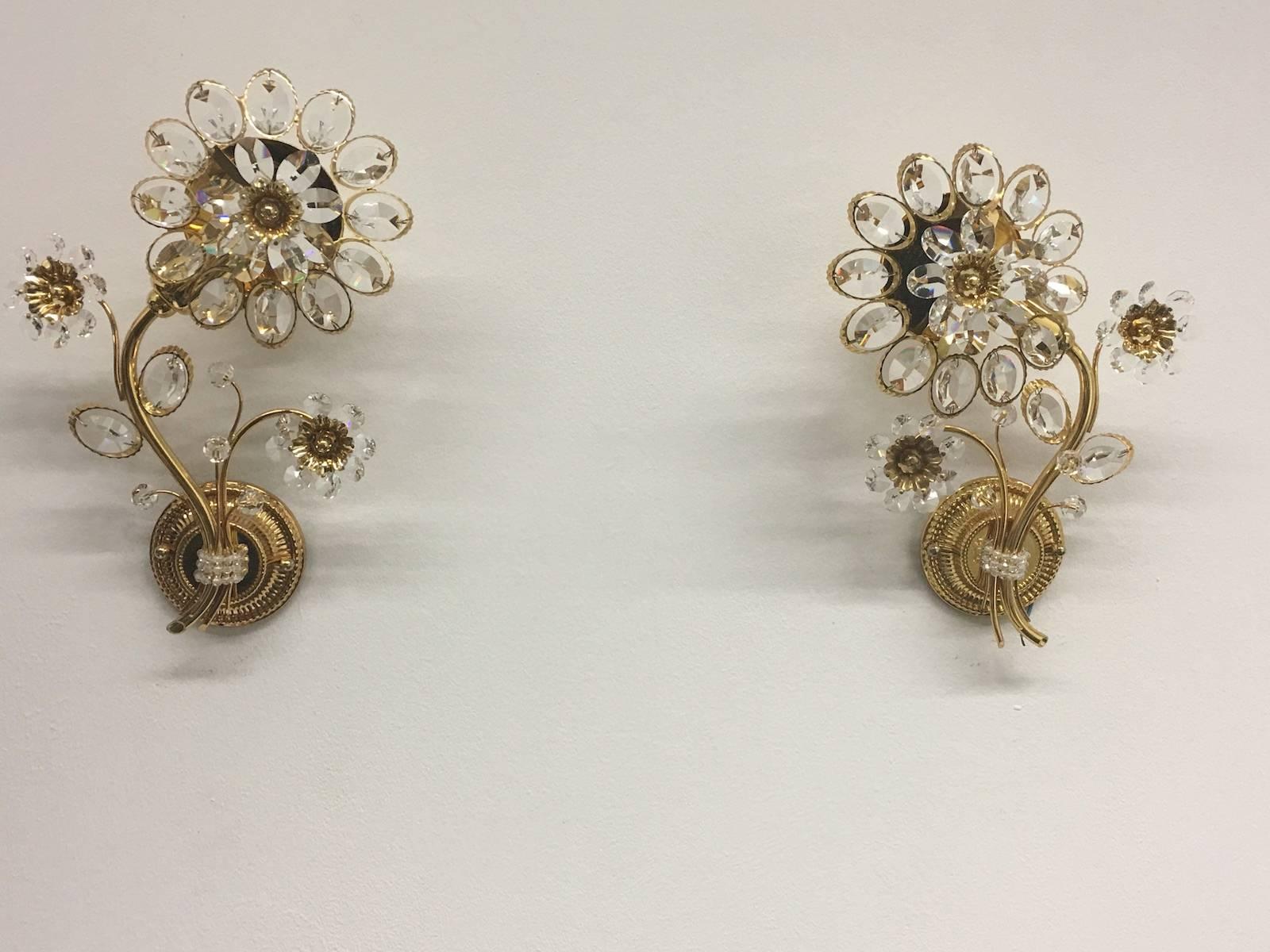 Pair of vintage gold-plated sconces with faceted crystal flowers made by the German company Palwa. Each fixture has one European style E14 socket. It requires one European E14 candelabra bulb.