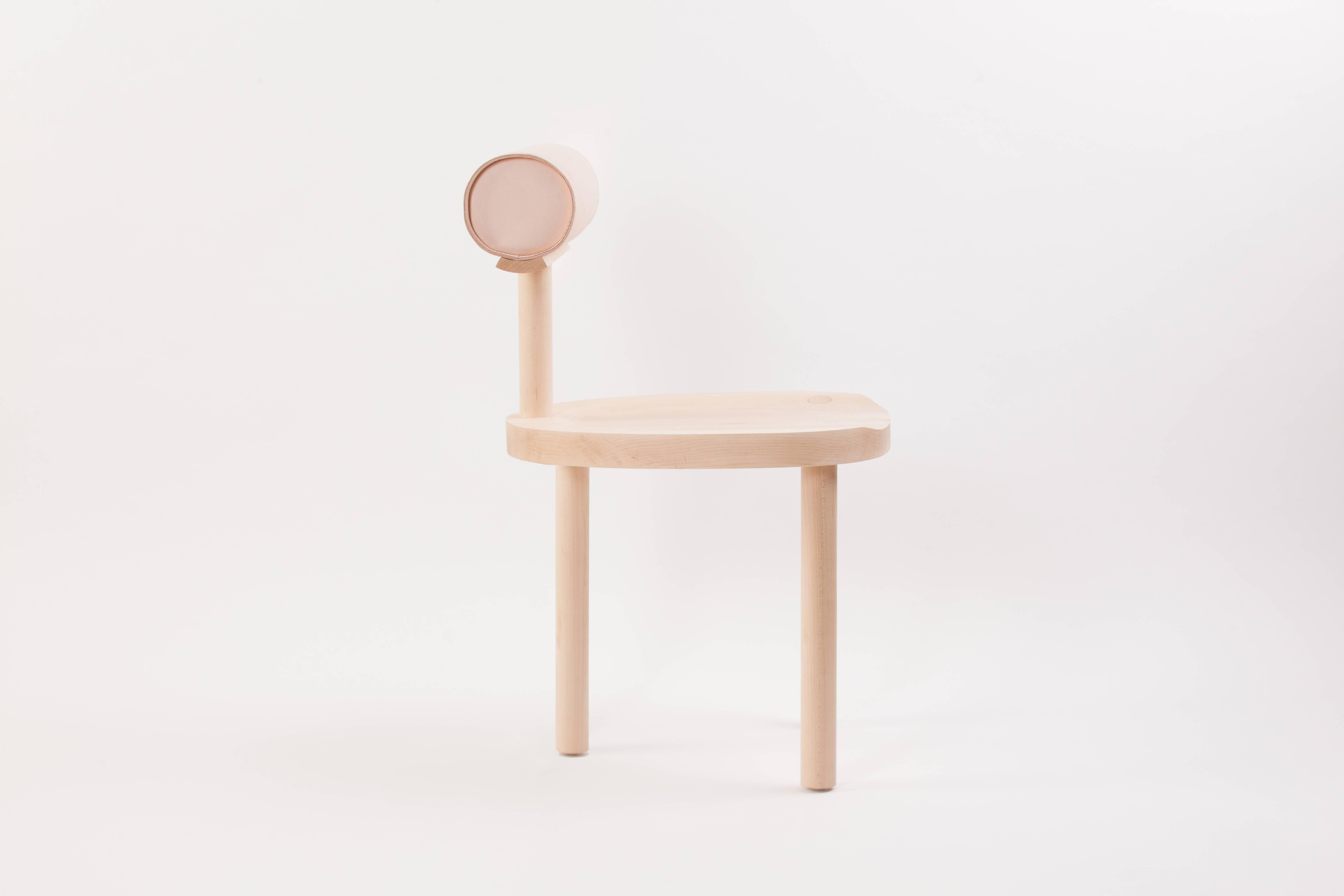 Der UNA-Stuhl verbindet eine runde Sitzfläche und Beine aus Holz mit einer ledergepolsterten zylindrischen Rückenlehne. Die Verwendung dieser fließenden Formen ermöglicht eine stärkere Konzentration auf die Details der Holzmaserung und der makellos
