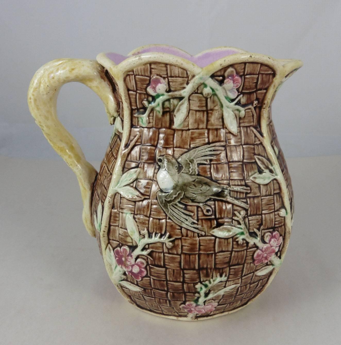 English 19th Majolica pitcher decorated with bird and pink flowers
on a brown basketweave.
A larger pitcher is available (H / 7.5
