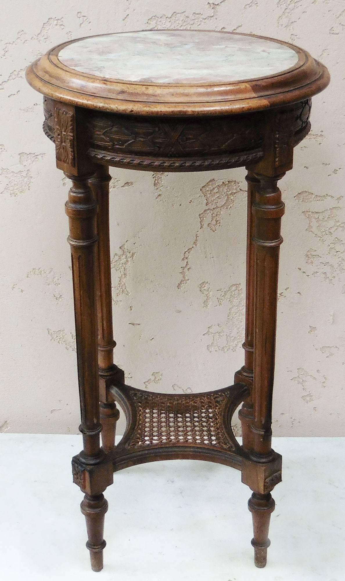 Elegant French carved round gueridon with a pink marble in Louis XVI style, and a canework shelf, circa 1900.