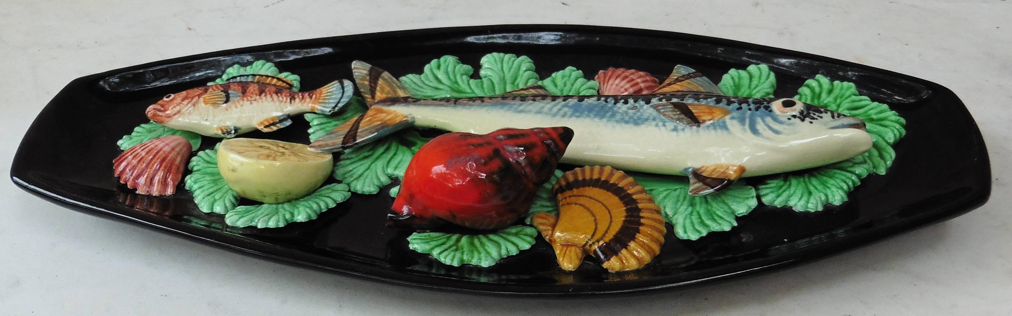 Large oval Majolica Palissy wall platter attributed to Vallauris, circa 1950.
A large mackerel on a seaweeds bed, lemon slice, shells and one small fish.
 
