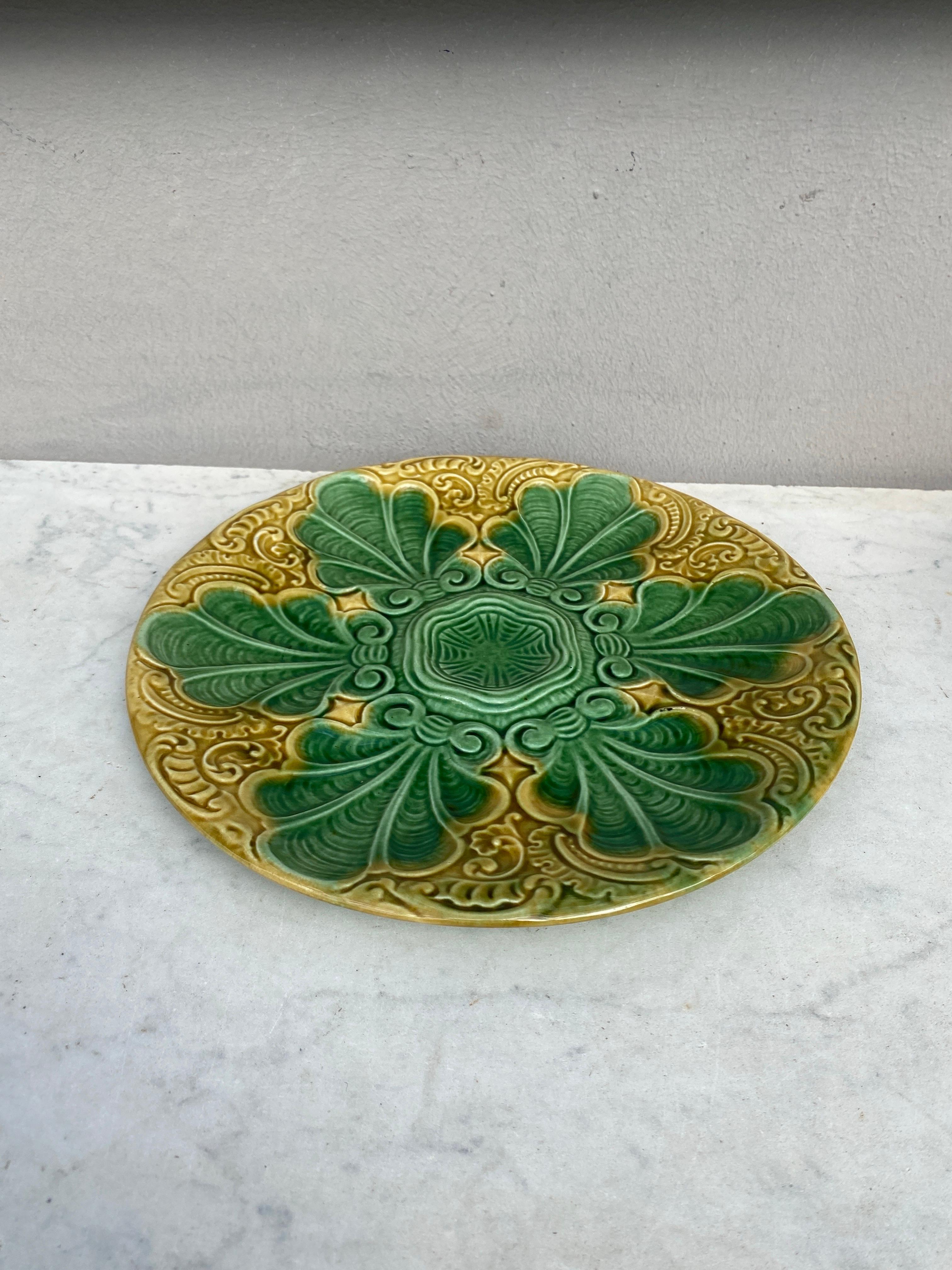 Piatto da ostrica in maiolica francese colorata verde e gialla con foglie stilizzate, circa 1890.