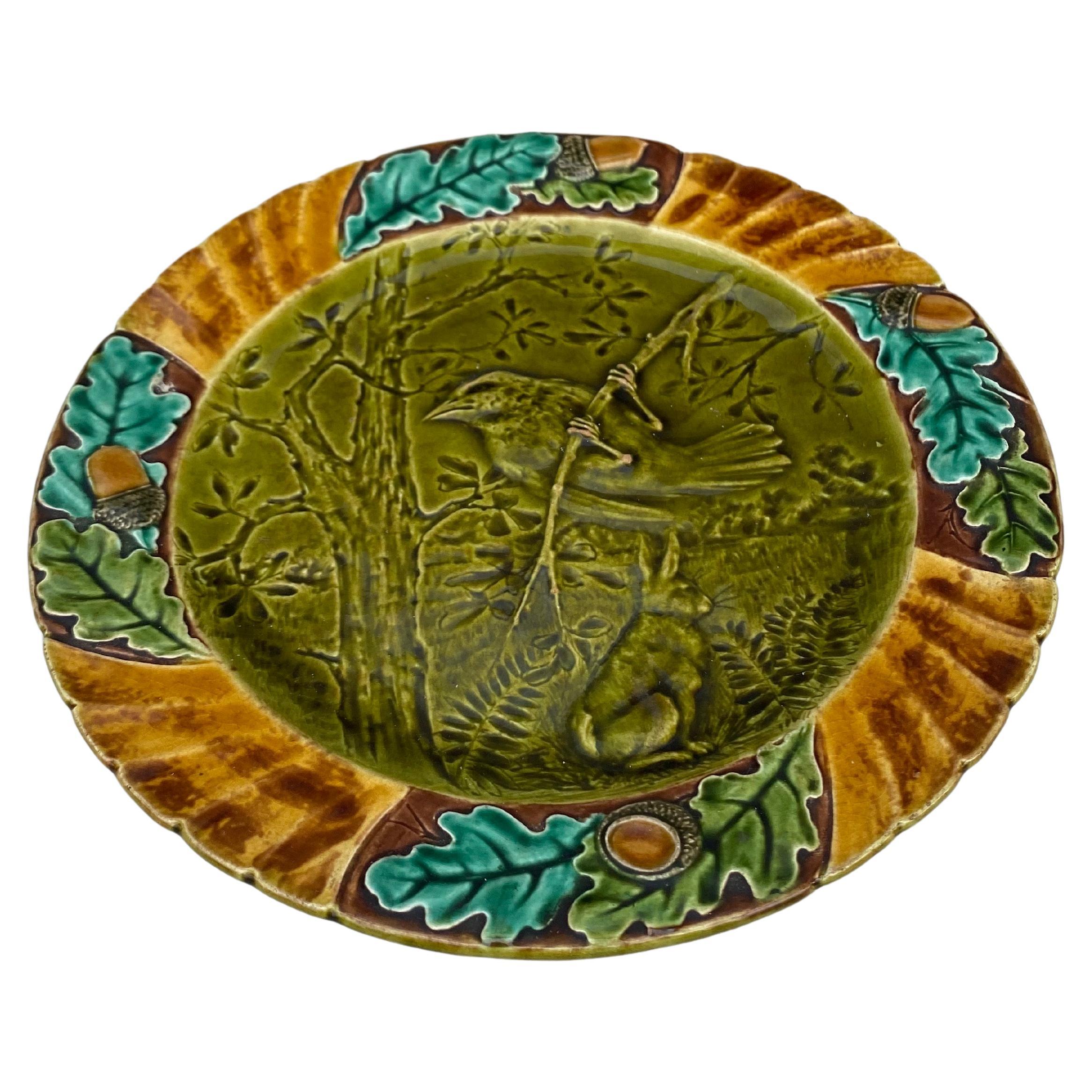 assiette à oiseaux en majolique du XIXe siècle signée Sarreguemines.
Cette assiette représente l'automne avec des feuilles de chêne.