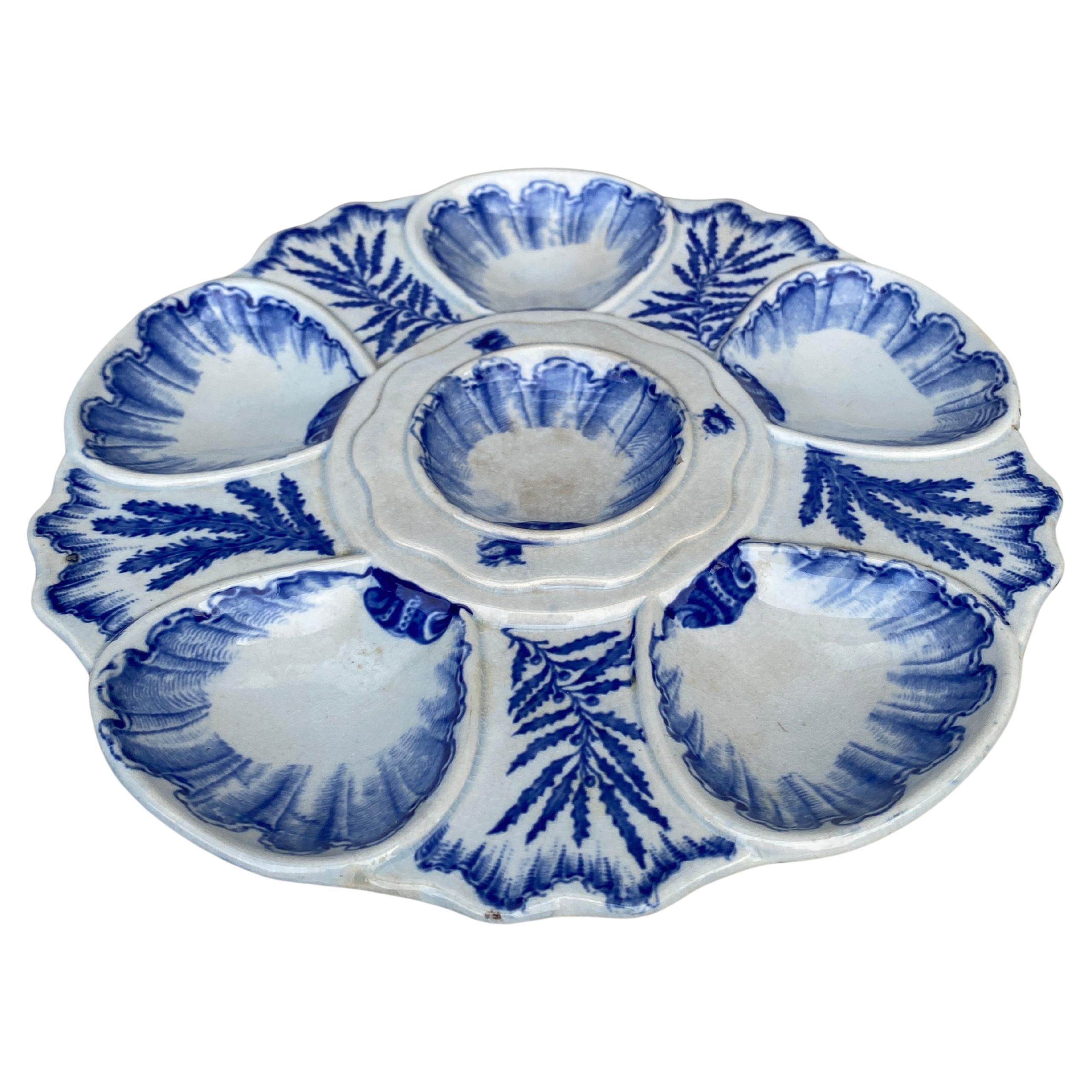 Elégante assiette à huîtres bleue et blanche signée Bordeaux Vieillard, vers 1890.
Six puits entourés d'algues bleues de différentes sortes.