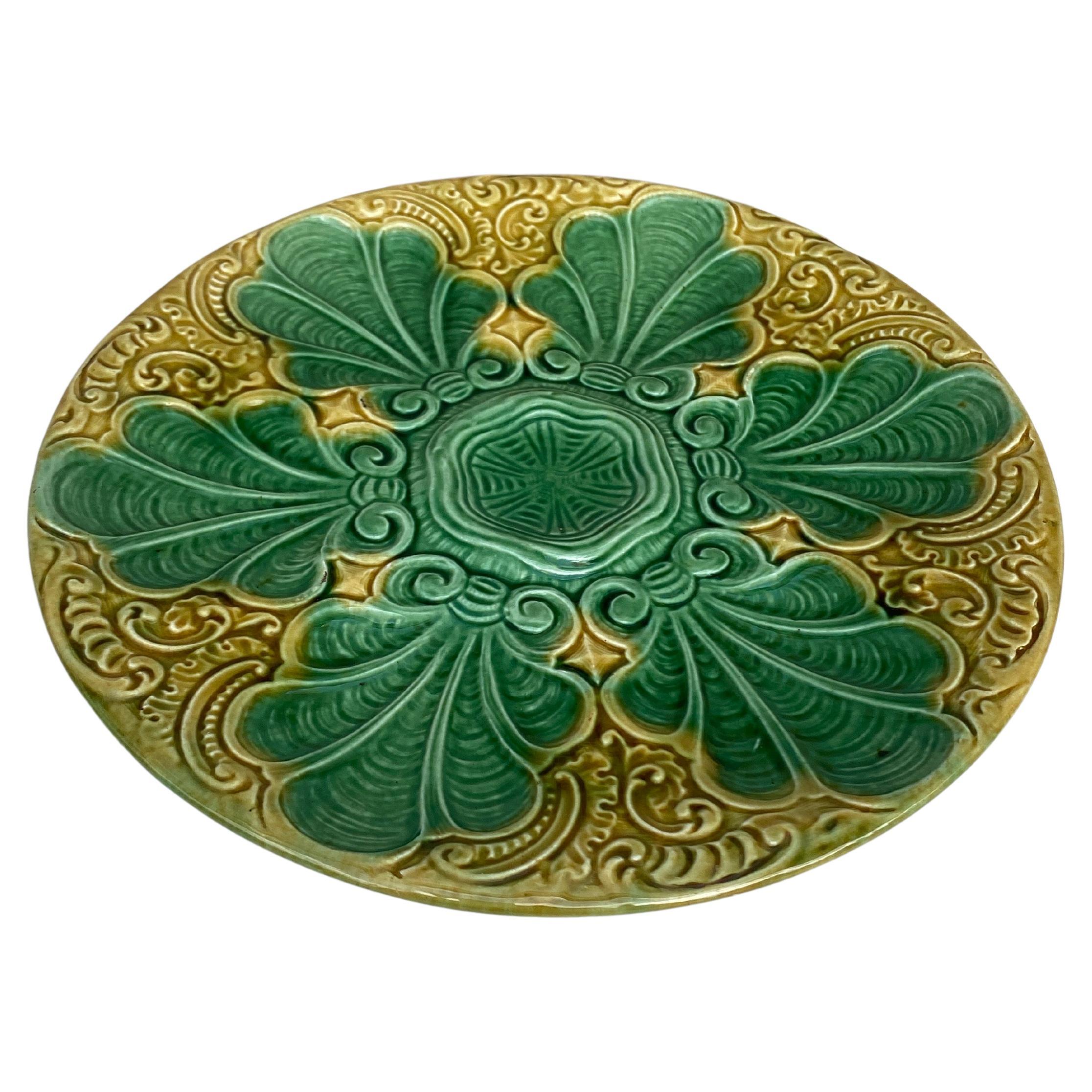 Plato de colorida mayólica francesa verde y amarilla con hojas estilizadas, hacia 1890.
