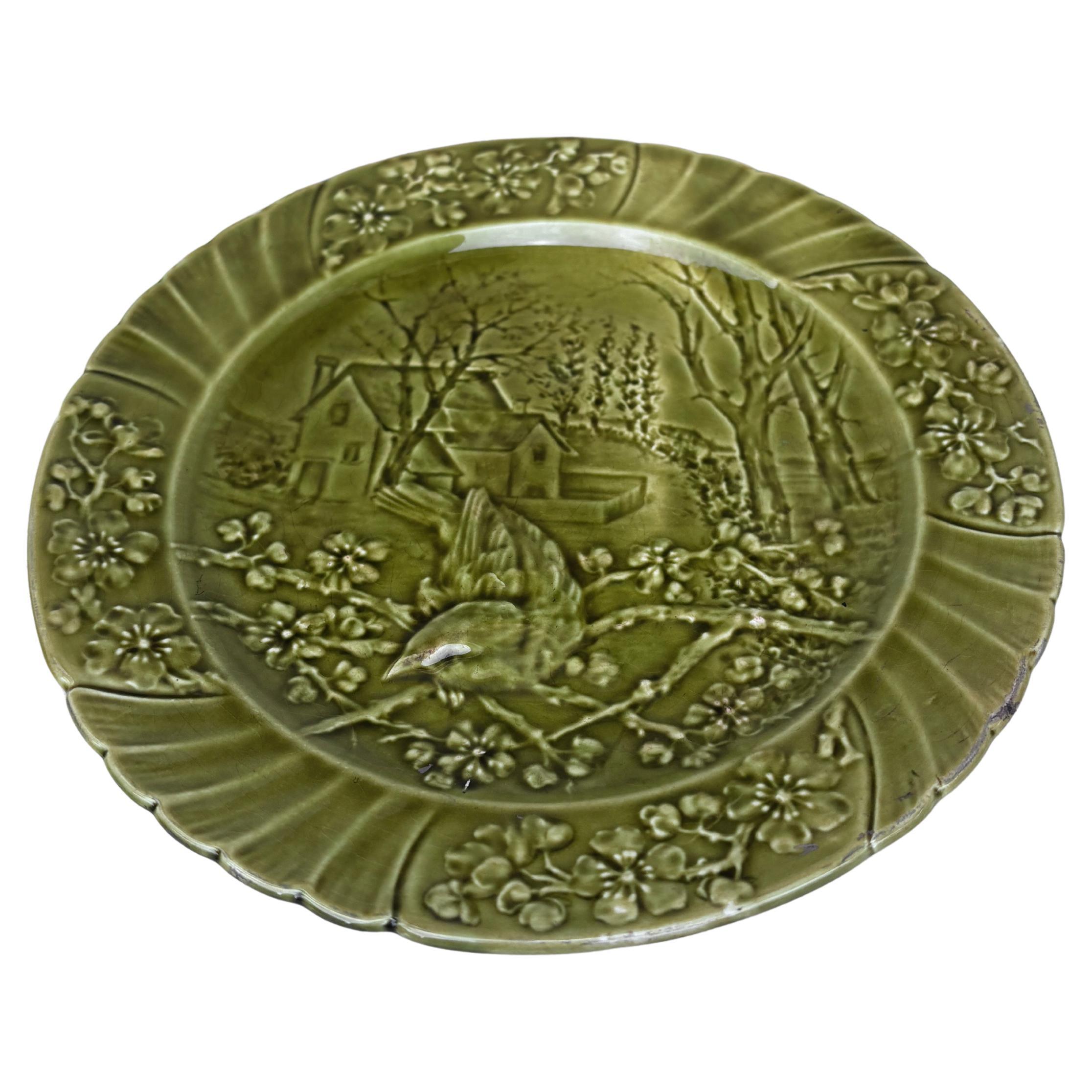 Plato de pájaro de mayólica verde del siglo XIX firmado Sarreguemines.
Este plato representa la primavera con flores de cereza.