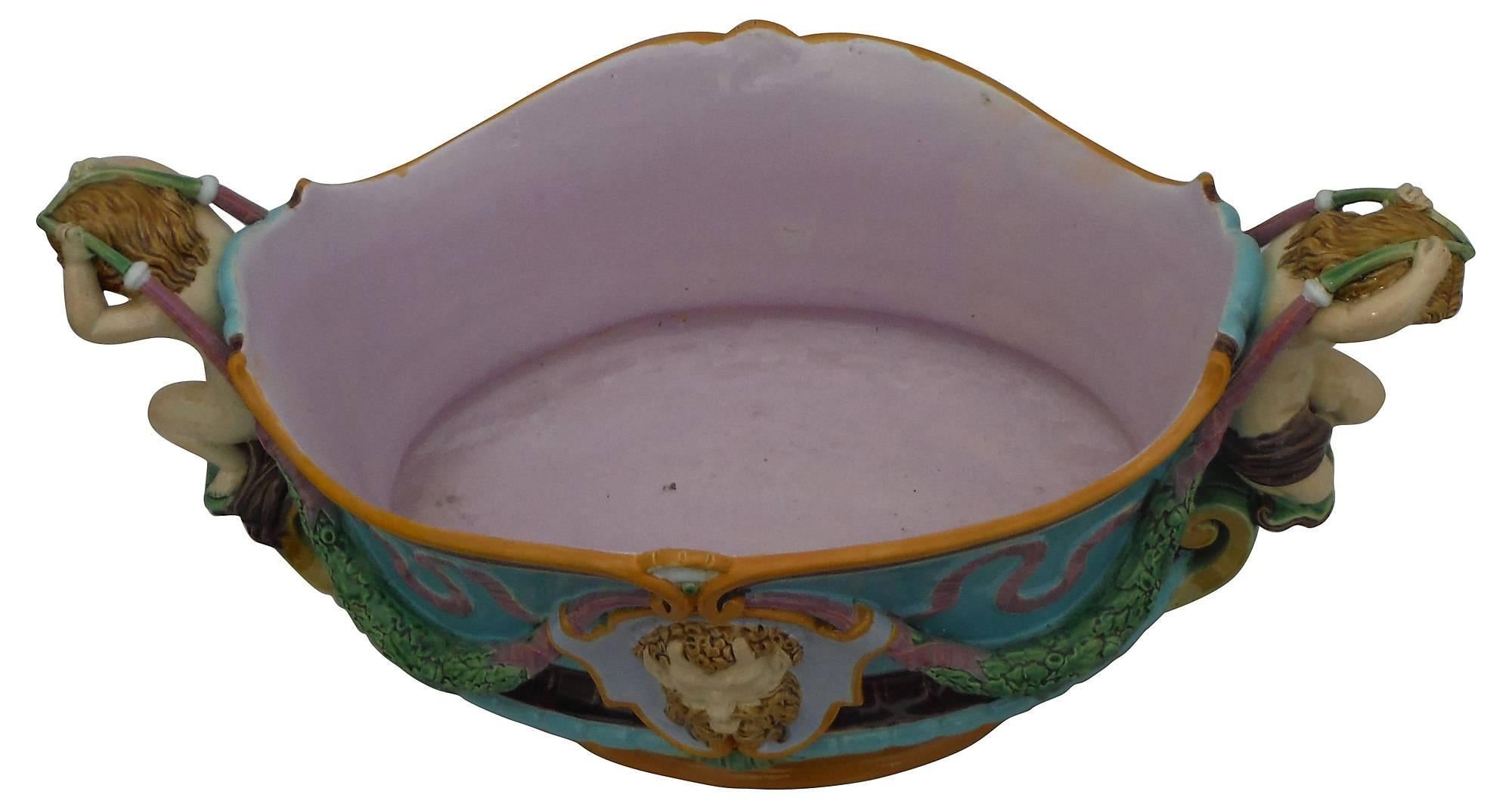 Classical style for this large Majolica jardiniere or table centre signed Minton and dated 1876 cherubs handles and masks on each side of Renaissance Revival. On the middle of 19th century Minton started to produced Majolica highly inspired by the