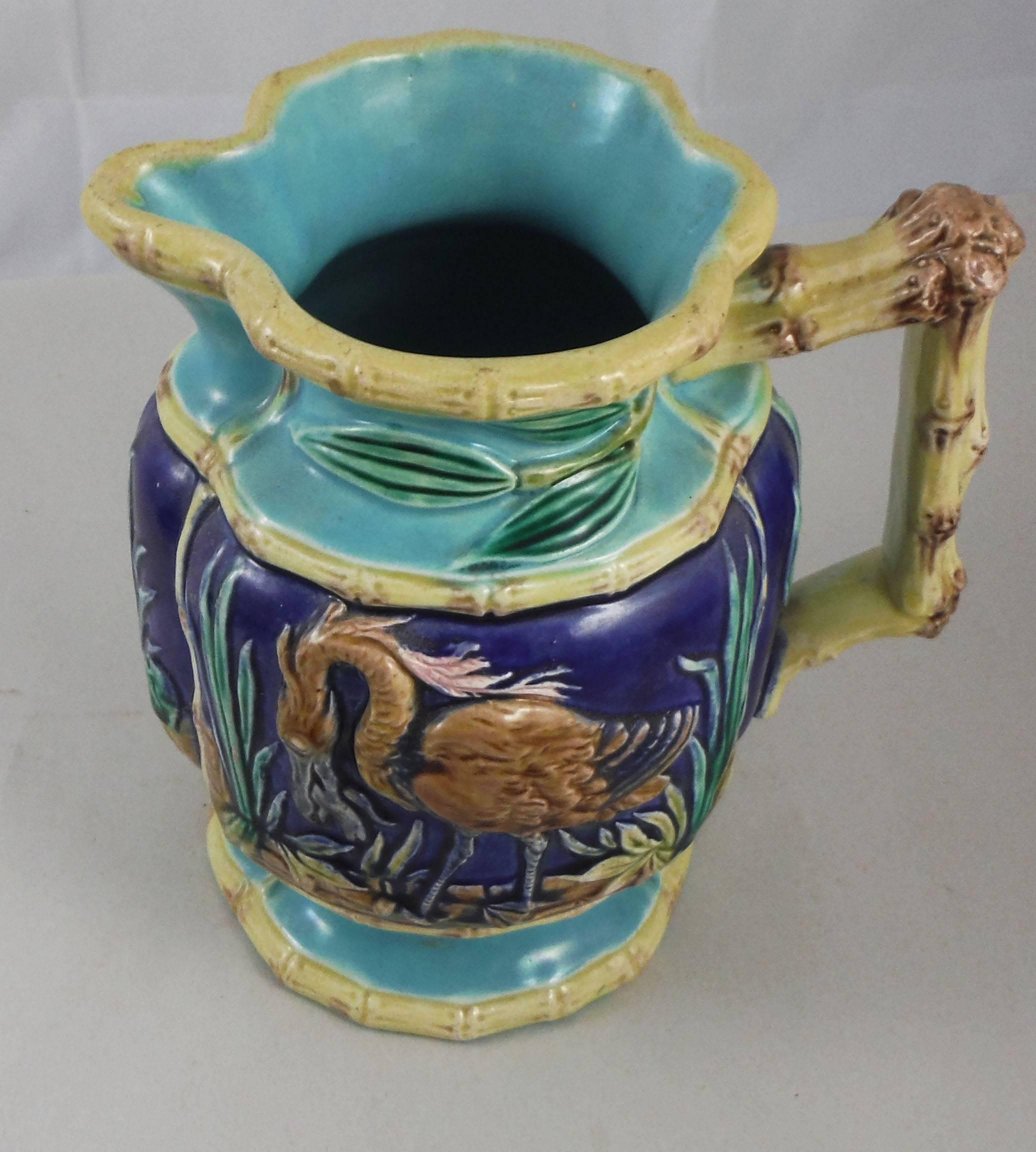 19th century English Majolica pitcher with birds on a cobalt background surrounded by bamboo, it's an harmonious composition of the colors between the yellow of the bamboo, the aqua turquoise and the cobalt blue.
This pitcher is attributed to