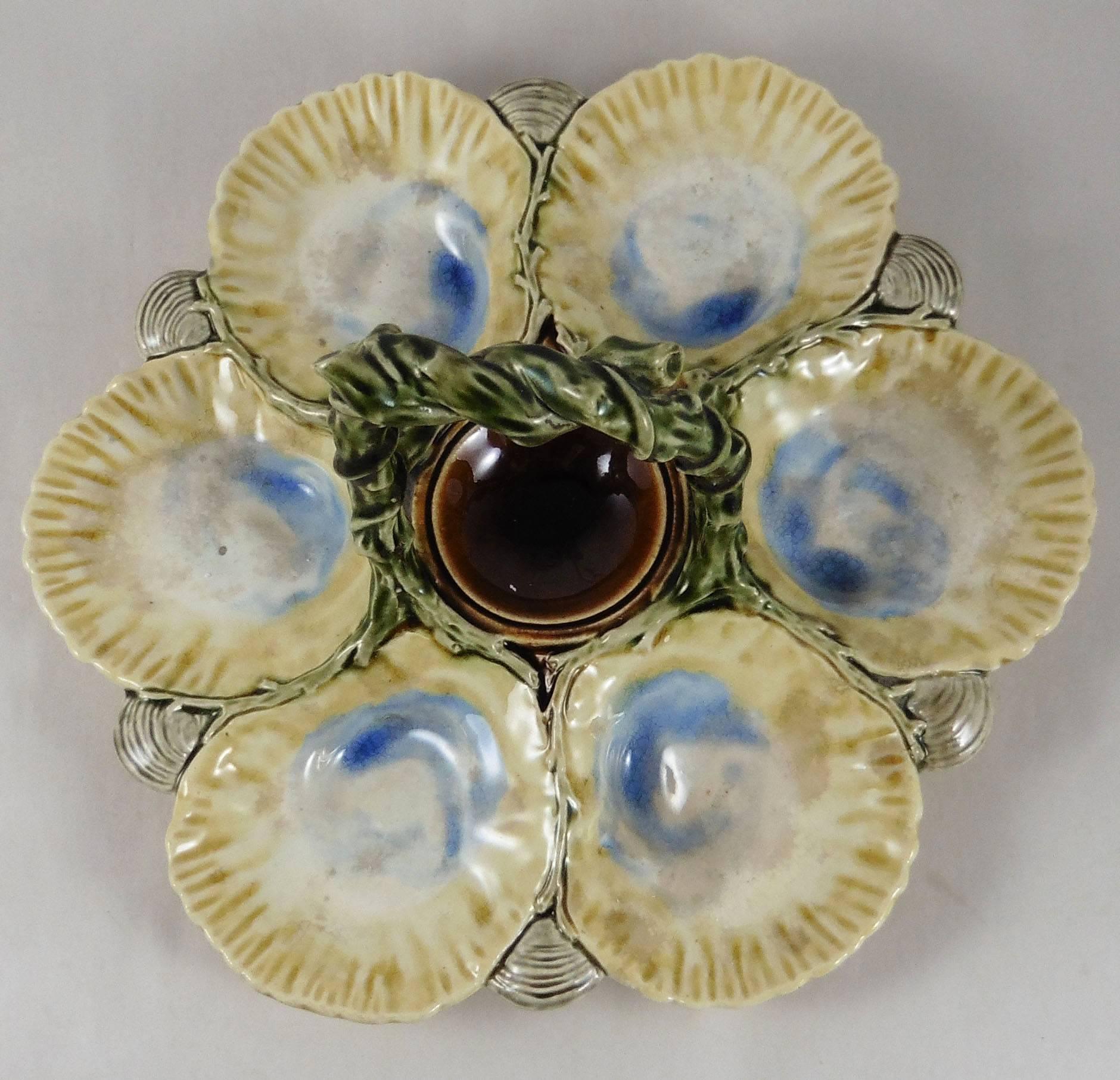 Very rare Majolica oyster basket server signed Hippolyte Boulenger Choisy Le roi, circa 1880.
The handle is a branch who form a knot on the top, between the six yellow and purple oysters shells, small grey shells, the center of the platter is the