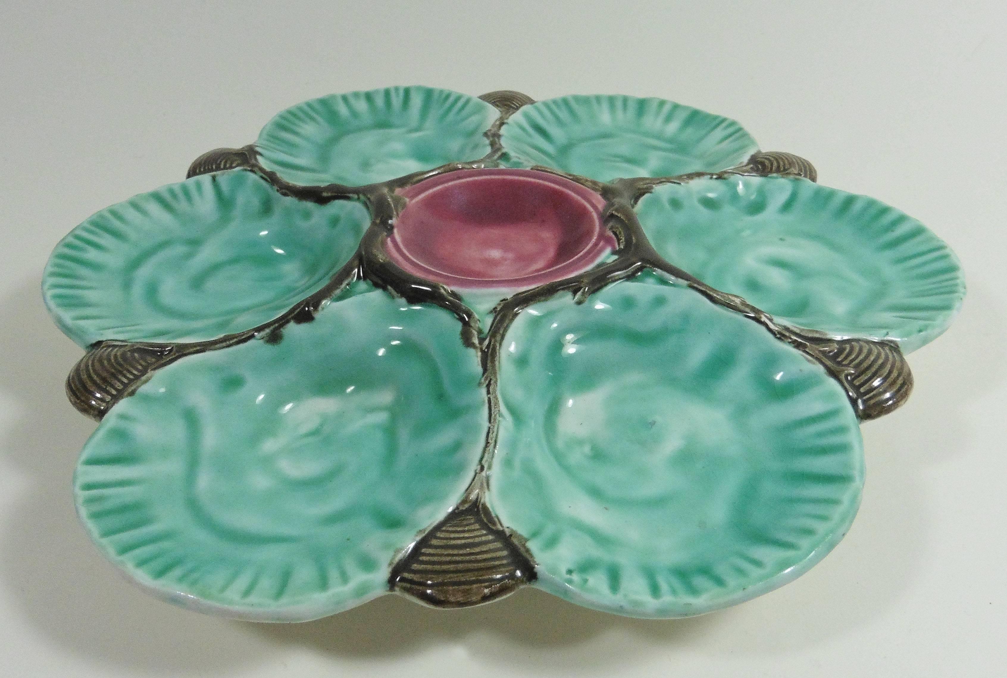 Colorful and rare Majolica oyster plate Choisy Le roi unsigned circa 1890.
The six wells are aqua turquoise between grey shells and the center is red pink.
.