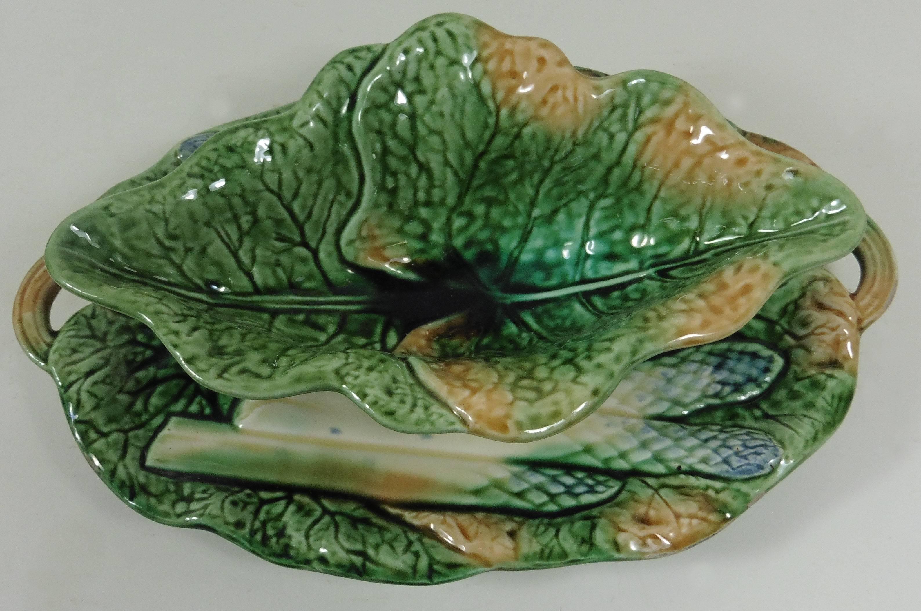 Rare Majolica asparagus sauce boat attributed to Creil et Montereau.
The piece is decorated with cabbage leaves and asparagus.
A set of plates is available in a rare yellow background.
Reference / Page 118 