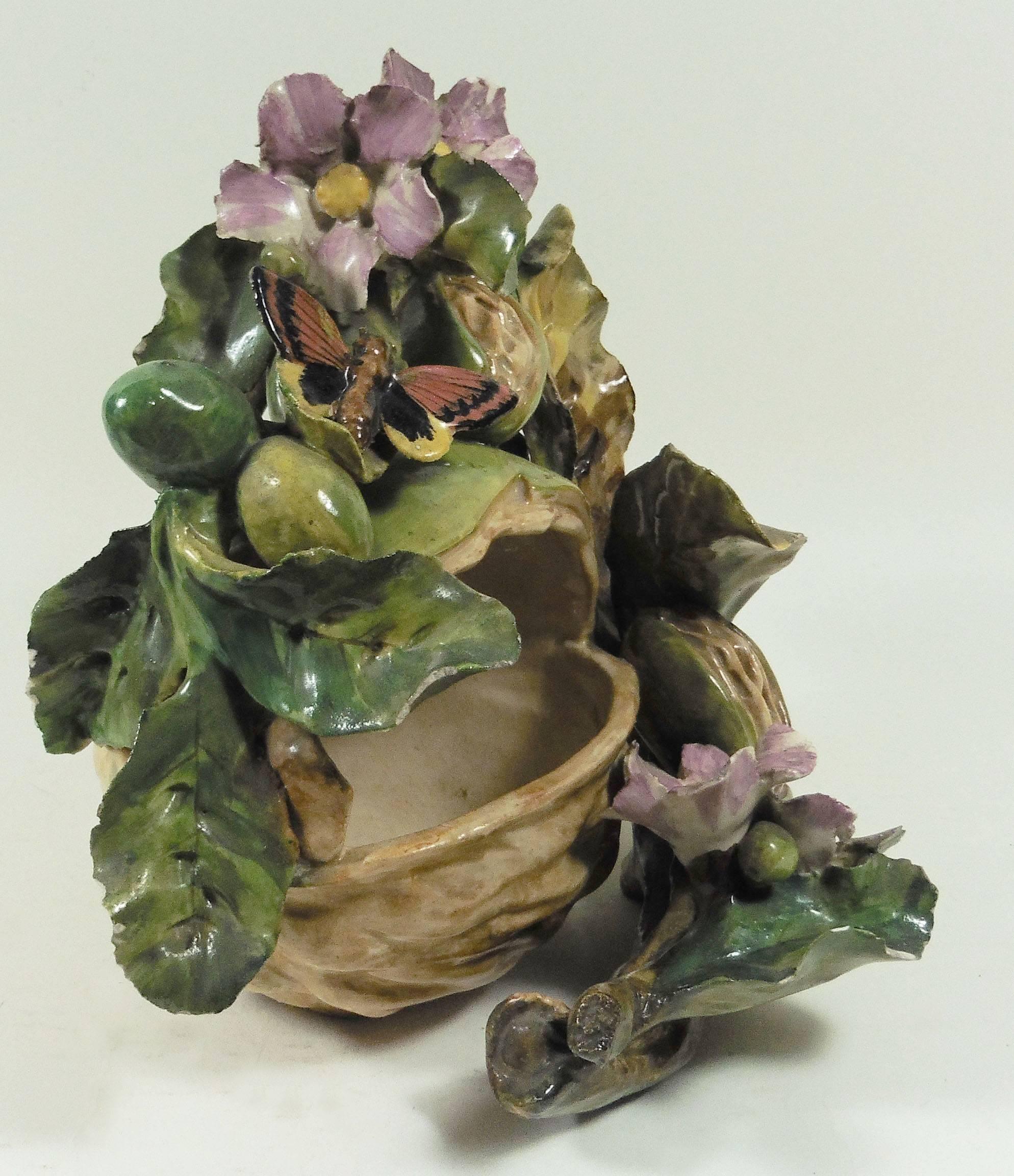 Unusual French Majolica large nut surrounded by leaves and pink flowers, a red butterfly against the leaves, circa 1880, signed Jean Pointu.
Several pieces in this style with high relief flowers was made at the end of 19th century, associate to the