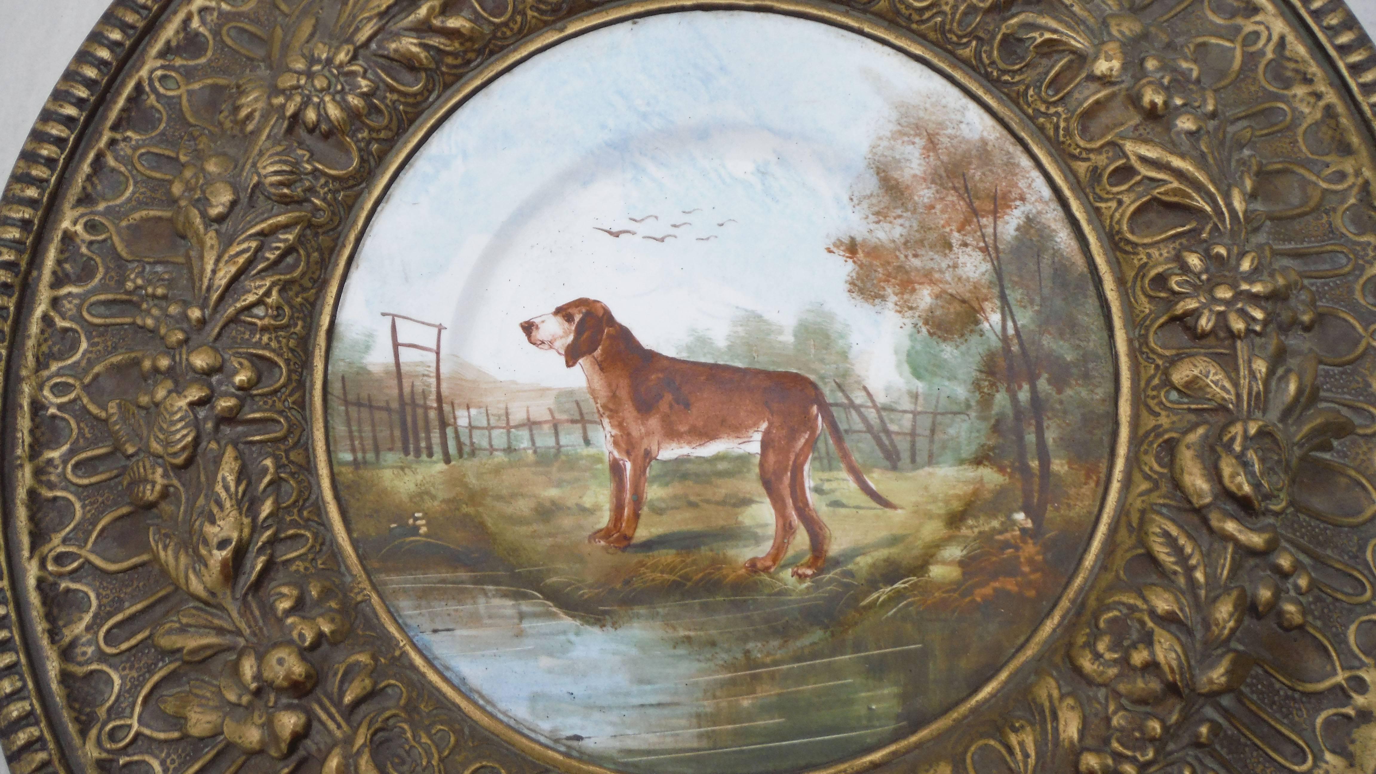 A large French faience plate framed by brass signed Choisy le Roi, circa 1880.
The faience plate represent a hunting dog in a landscape. The brass is entirely decorated with flowers and geometric pattern.