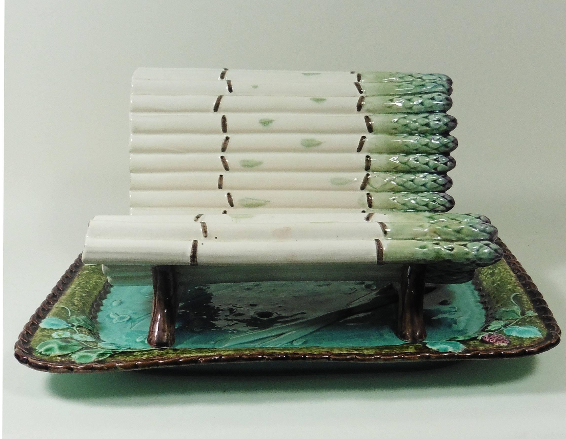 A remarkable 19th century large Majolica asparagus complete server composed with a turquoise platter decorated with asparagus and strawberries and a craddle shaped like a bench of asparagus signed Luneville.
Platter, 13