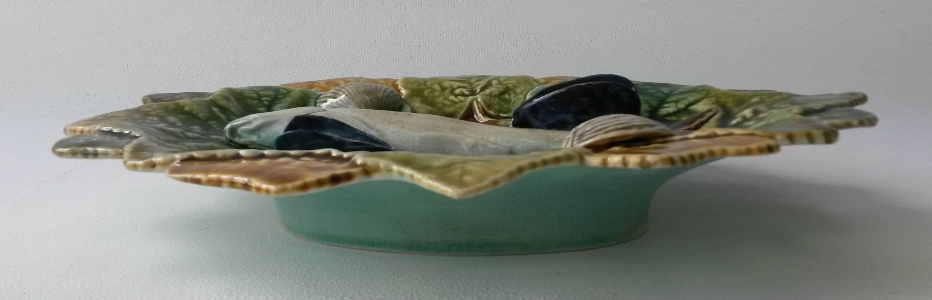 Colorful Palissy wall platter decorated with a fish lying on green and yellow leaves signed Hippolyte Boulenger & co Choisy le Roi, circa 1880.
The platter is decorated with mussels and shells.
  
