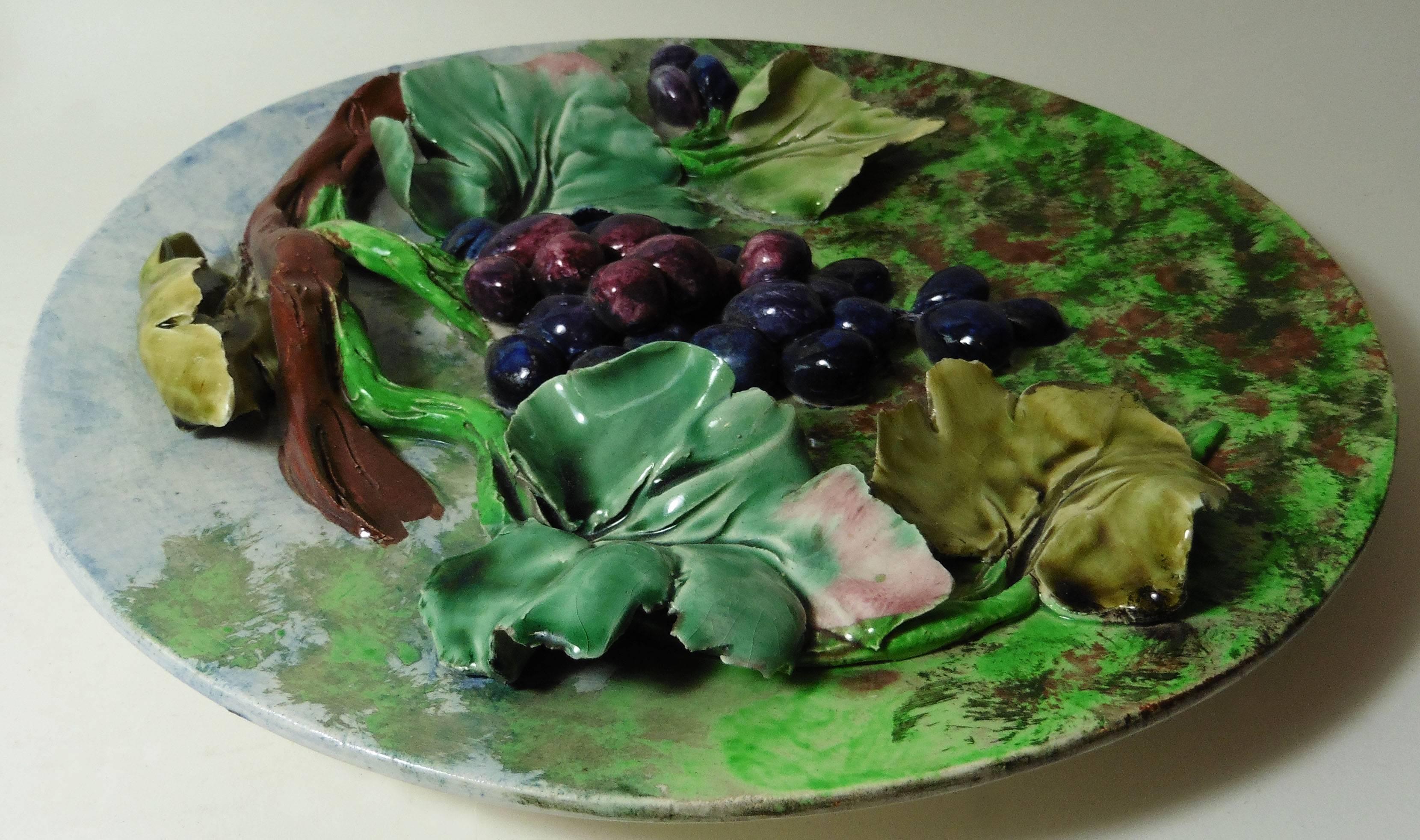 Colorful 19th century French Majolica grapes wall platter signed Longchamp terre de fer. The fruits are in high relief with the leaves and branches.
The manufacture of Longchamp produced this fruits platters with various fruits in four different
