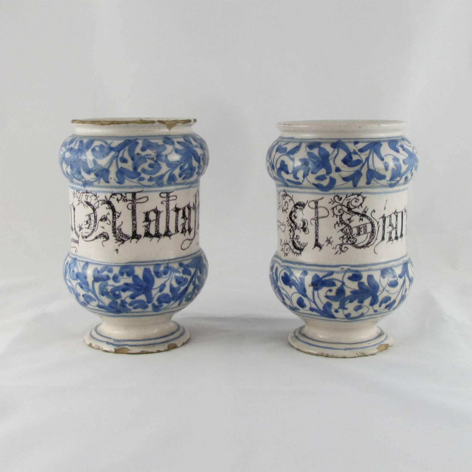 A beautiful pair of Albarelli, a type of Maiolica earthenware jars, originally medicinal jars designed to hold apothecaries’ ointments and dry drugs.
The jars are labelled ‘El Diacatolicon’ and ‘Alabastro’ in black letters and they feature a blue