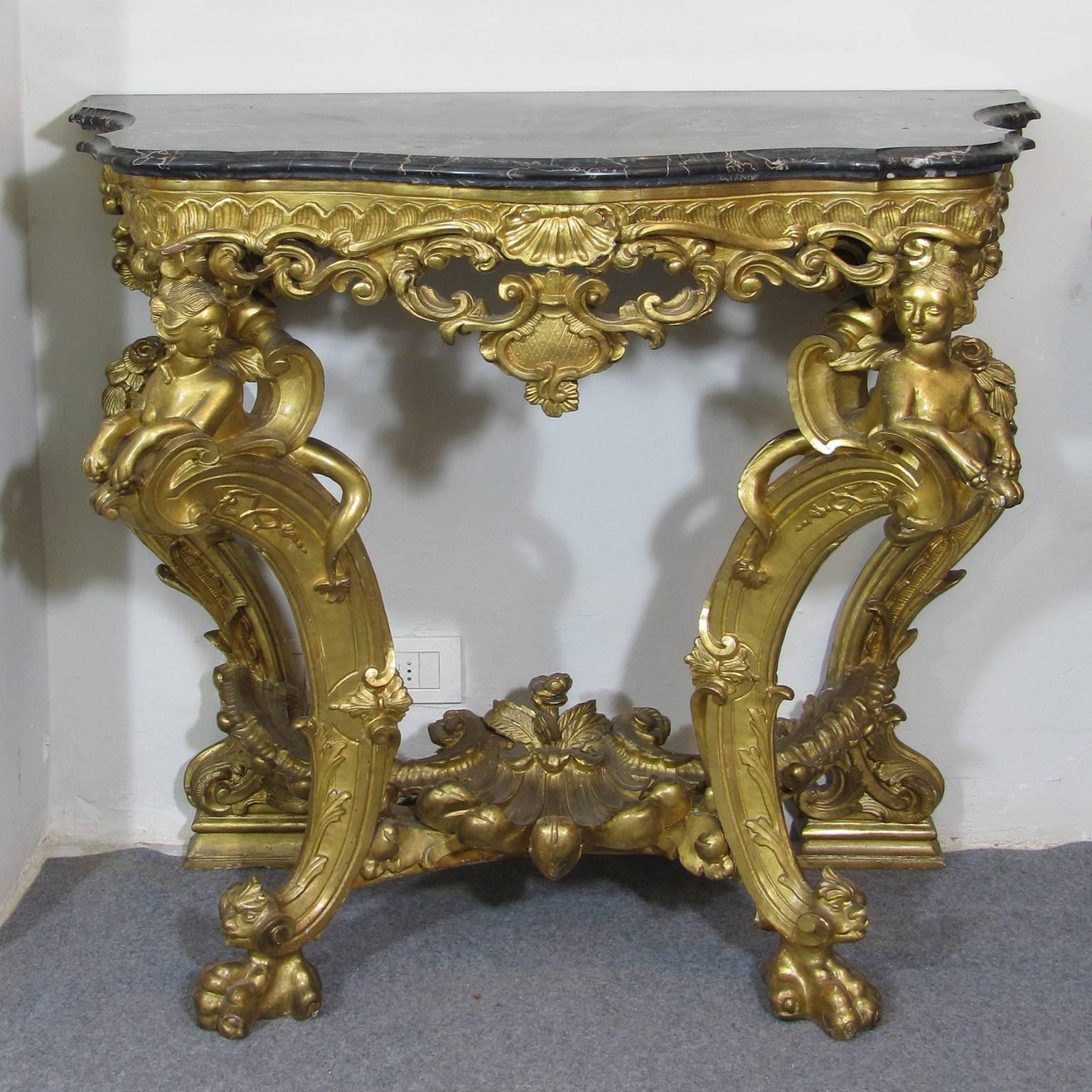 A particular Louis XV gilt and sculpted wood console or side table, freestanding on four cabriole legs each leg displays handsome paw feet.
The beautiful serpentine marble top is placed over the pierced frieze carved with C-scrolls and acanthus,