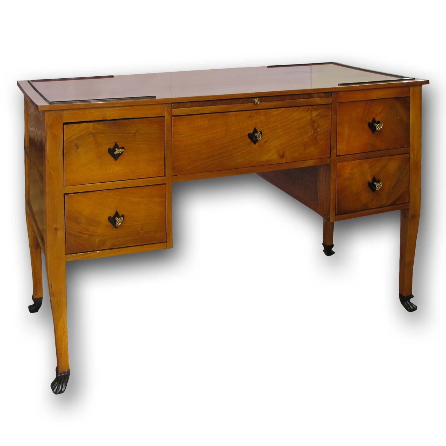 A beautiful Directoire writing desk or bureau plat in cherrywood with ebonized details and very elegant lines. The desk presents five drawers, a central slide with leather lined writing surface and four large hidden compartments. The desk is