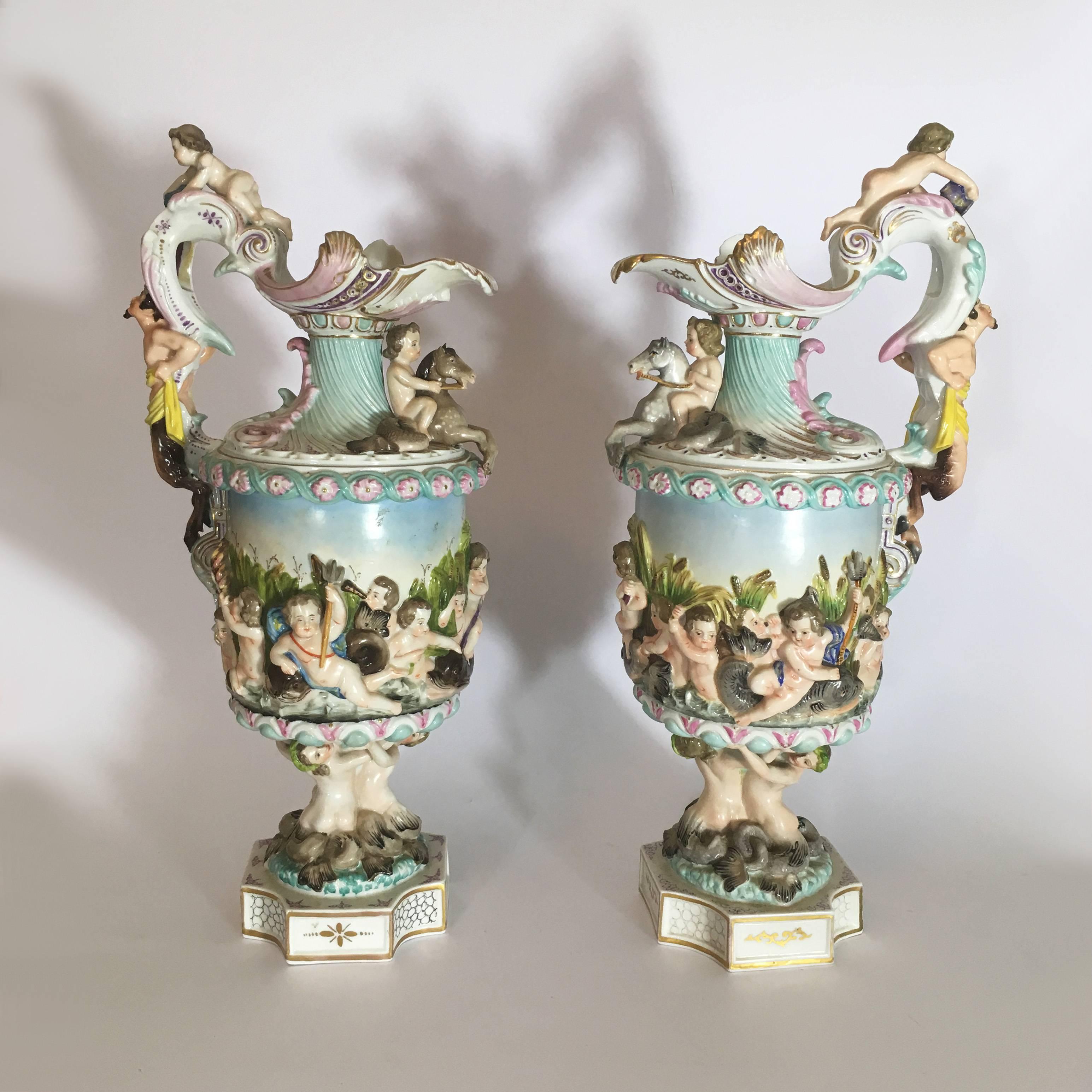 A stunning pair of antique Meissen porcelain ewers, featuring a maritime scene with dolphins, cherubs, mermaids and galloping horses. The ewer’s handles are presenting satyrs. Underneath the ewer’s bases are the Meissen symbols of blue crossed