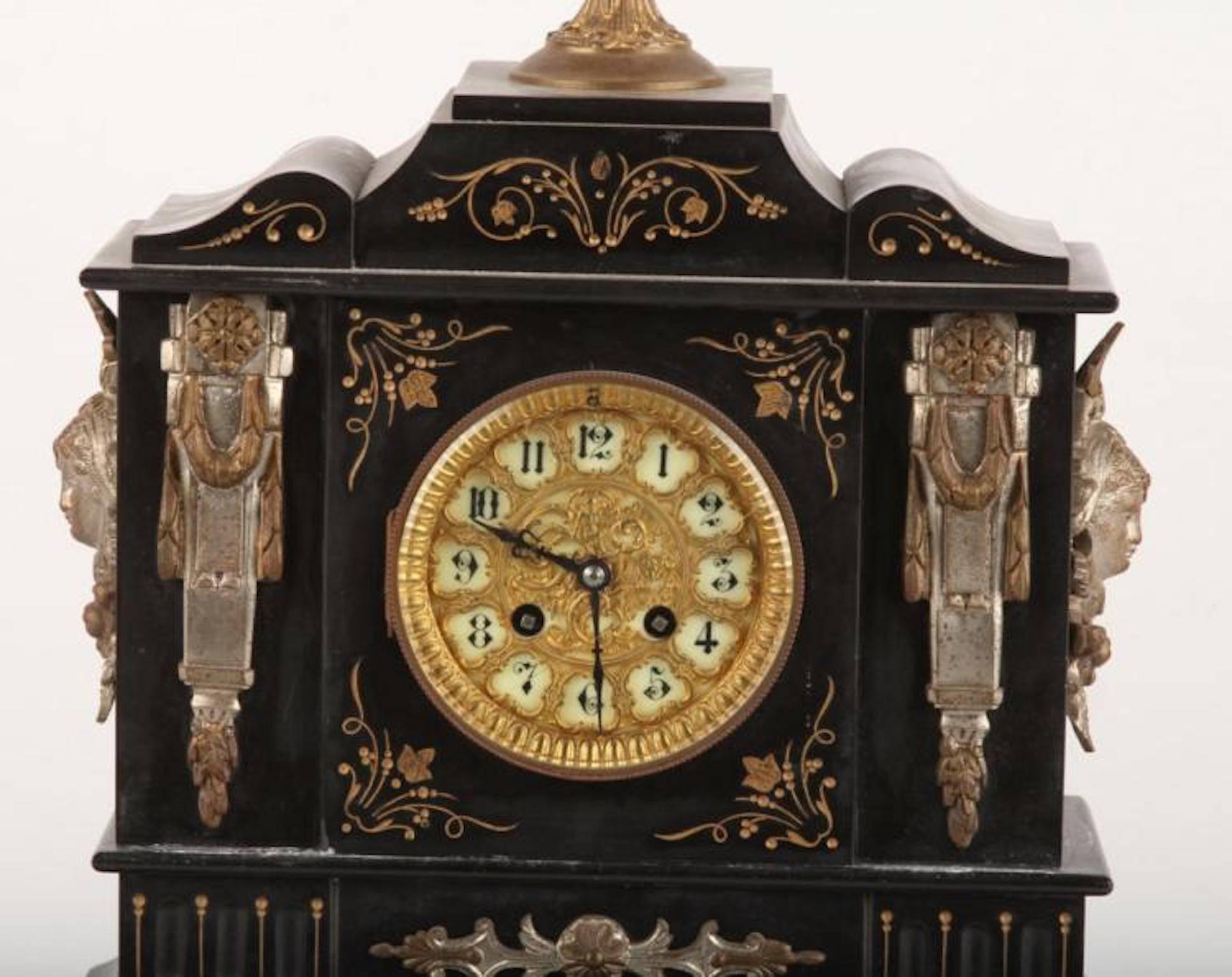 Black slate mantel clock by Ansonia late 19th century block and slate mantel clock. Engraved and gilded. Ceramic dial with brass garniture. Topped with an urn (top absent). A fine example of Victorian clocks. Size: 18.5