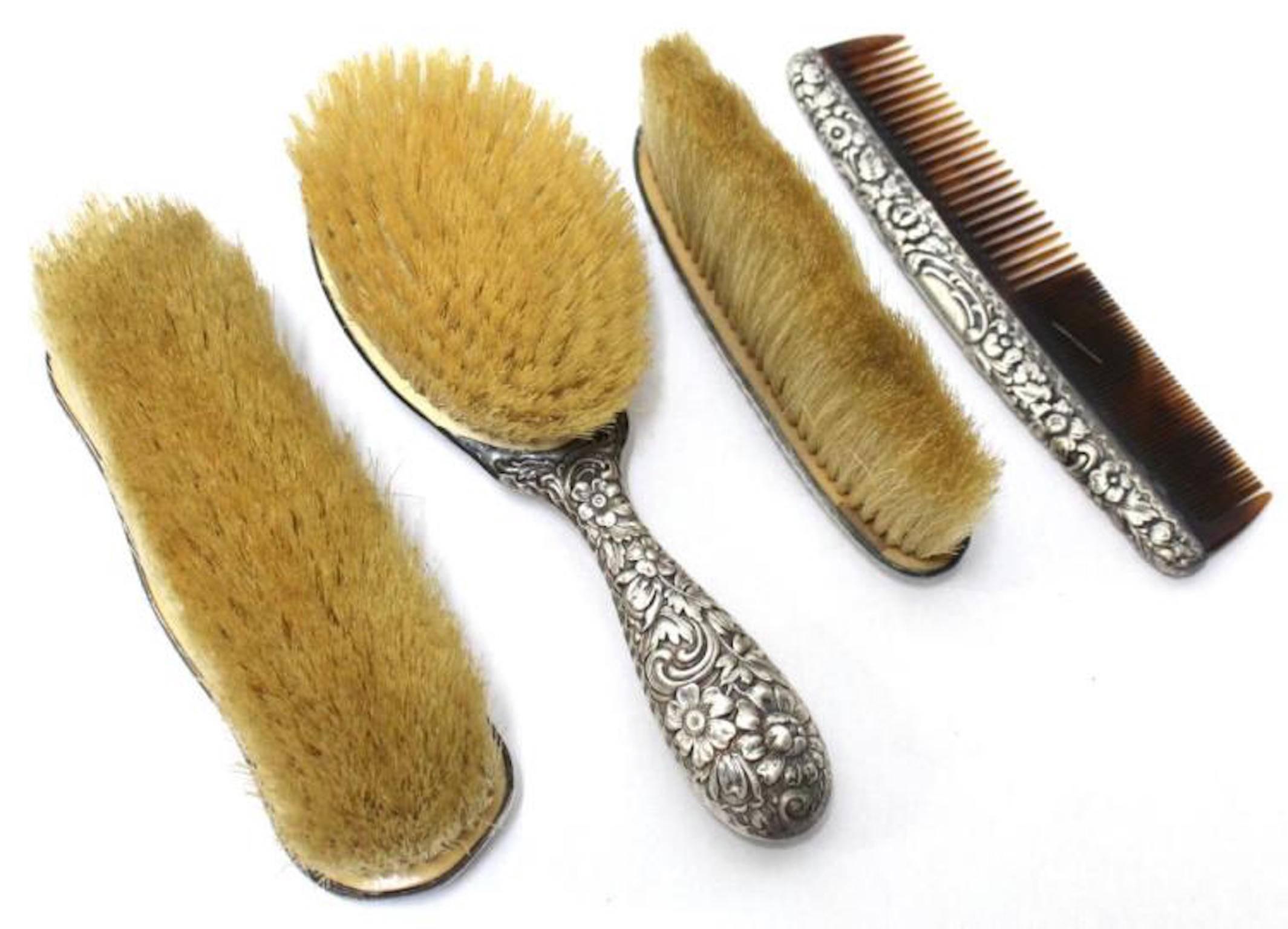 Assembled, comprising a hair brush, comb and clothes brush, each monogrammed "GBP," and a shoe brush monogrammed "JLG," each heavily covered in hammered roses, other flowers and C-scrolls, and with natural boar bristles. Longest: