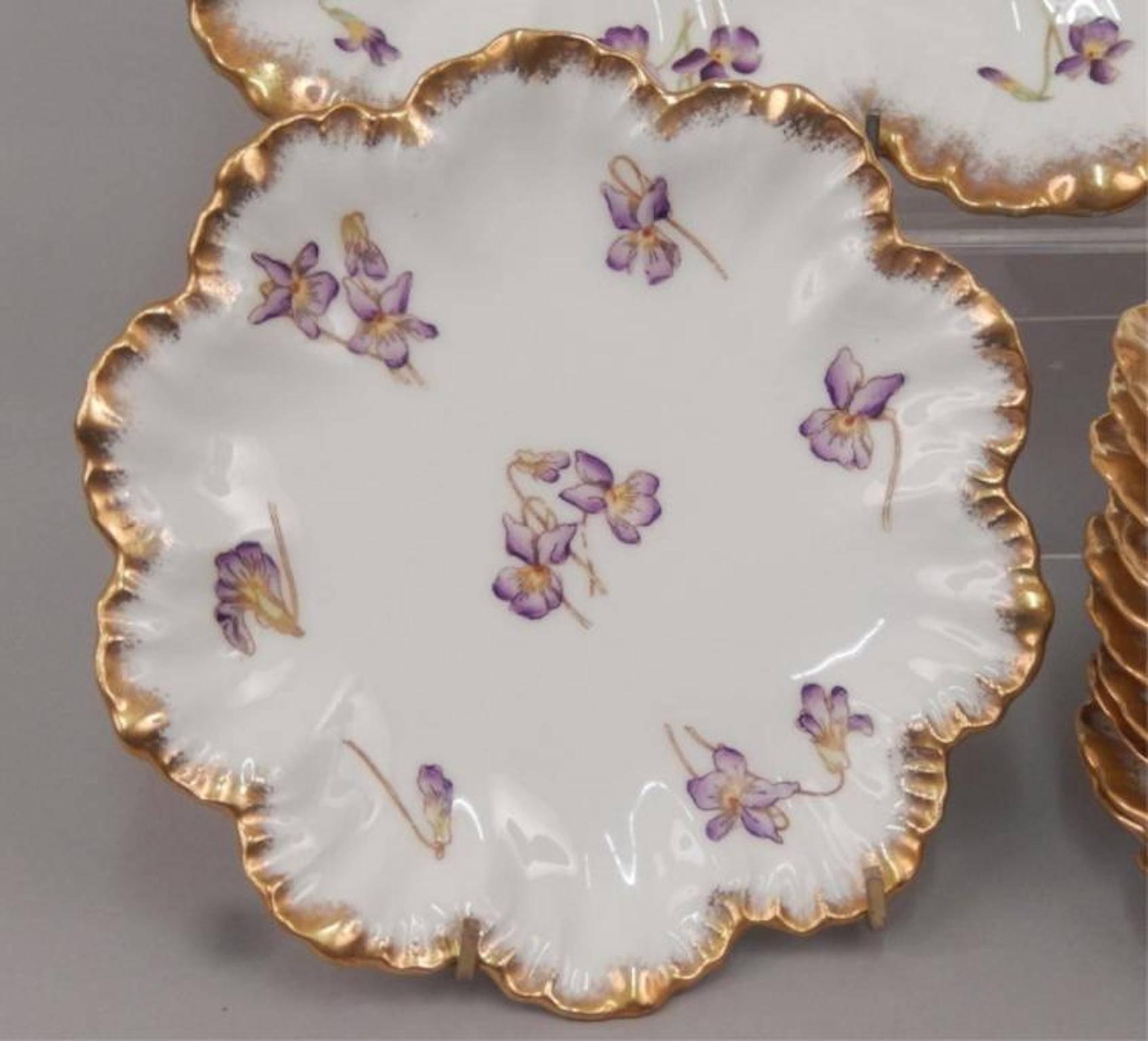 Limoges France porcelain ice cream set, including tray, 15 1/2" x 9" x 2 3/4" and 12 7" plates, all with gilt edge and violet pattern, early 20th century.