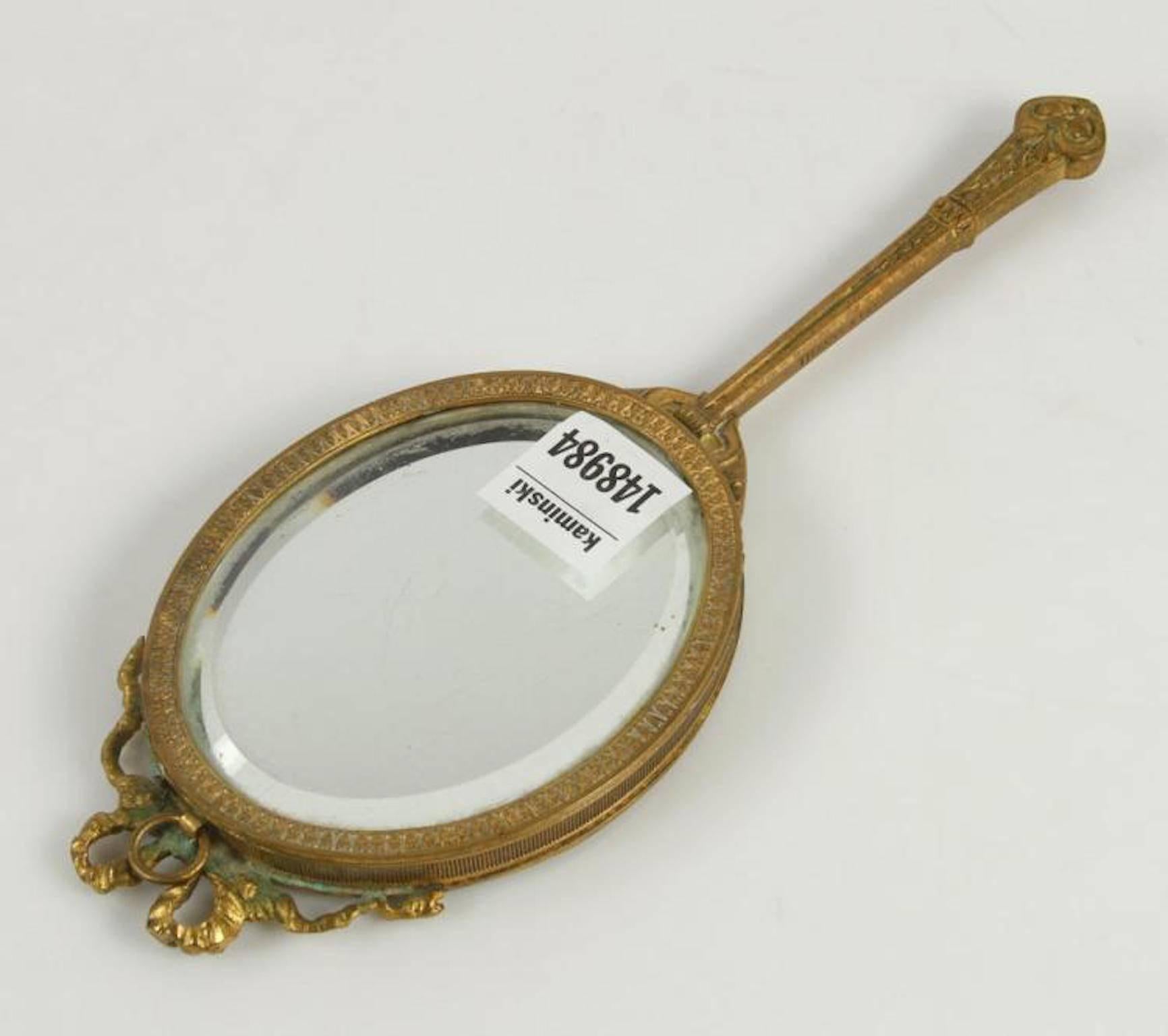 Tiffany & Co small bronze hand mirror, beveled, framed and lidded. Measures: 9 1/4" H x 3 3/8" W.