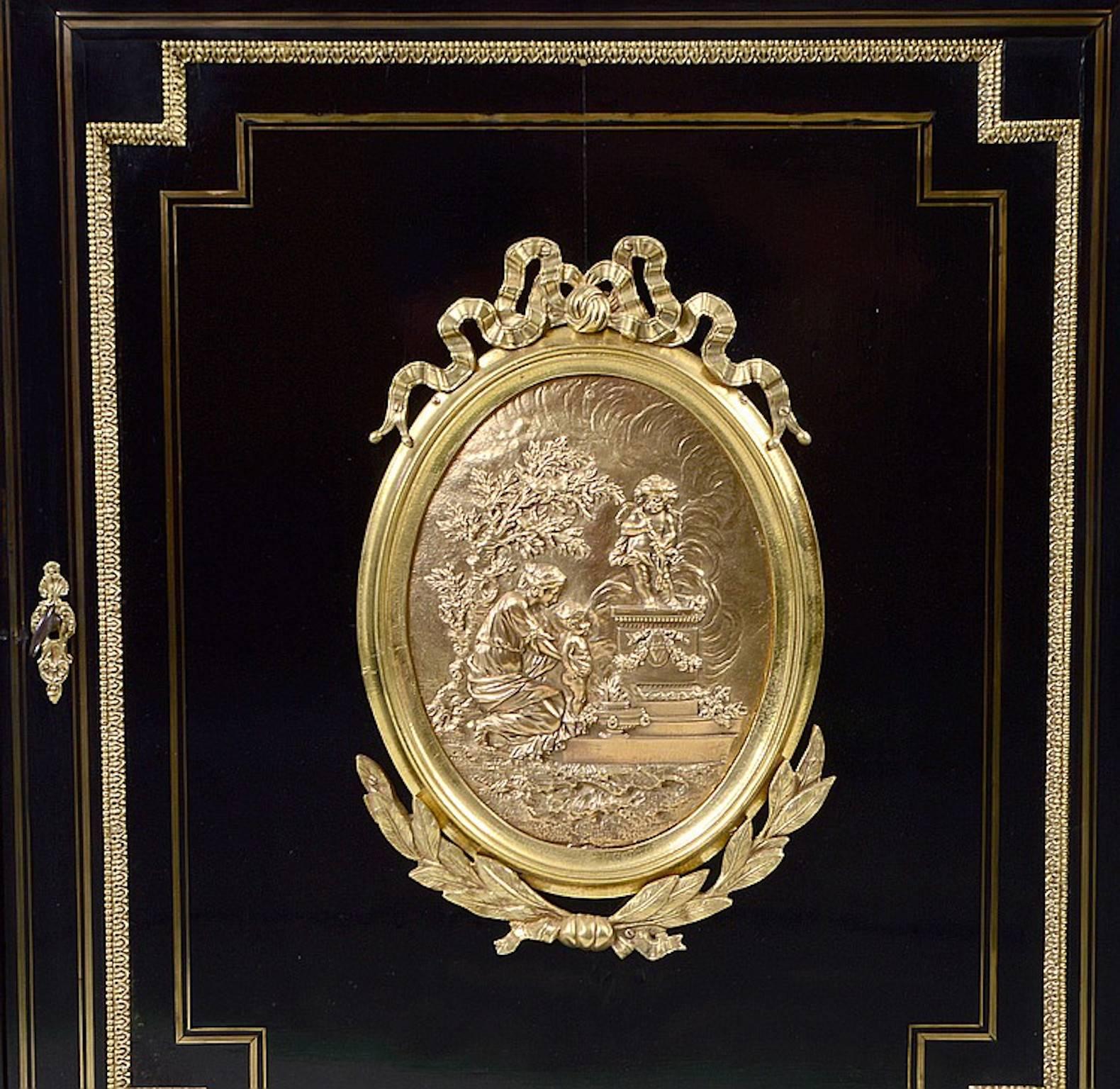 Napoleon III gilt bronze-mounted mahogany side cabinet,
French, 19th century. With rectangular marble top above a cupboard door applied with a figural plaque, raised on turret-form supports. Measures: Height 39
