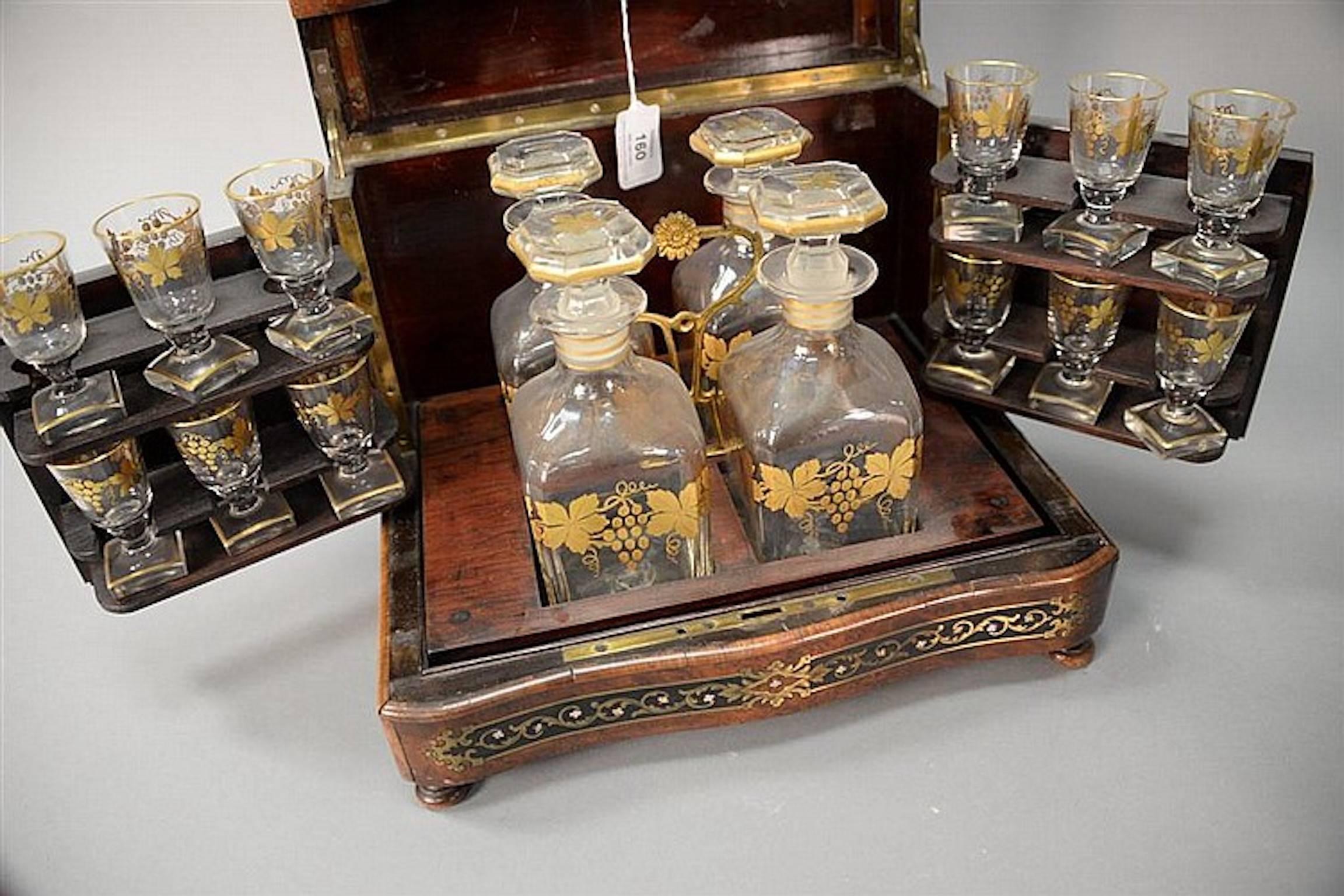 French burled cave à liqueur set with mother-of-pearl inlay, turn of the century French Napoleon style Tantalus decanter set having burled walnut, brass, and mother-of-pearl inlaid case with 14 bottle and 12 stem glass interior. Measures: height 10