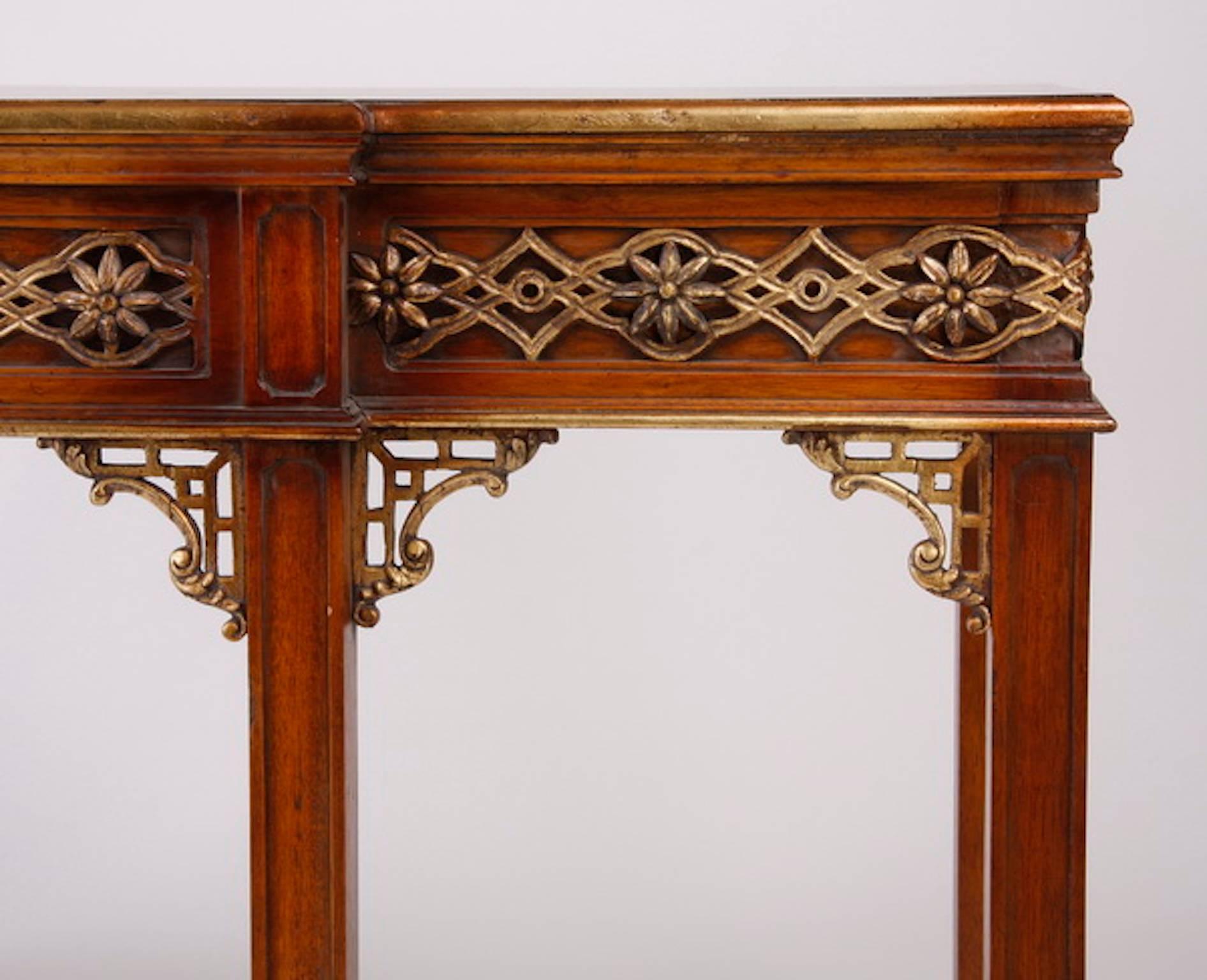 Carved mahogany console table, the parquetry inlaid top over a carved and parcel-gilt apron raised on Marlborough legs with pierce carved giltwood brackets. Measures: 36.5" H x 71.5" L x 24" D.
