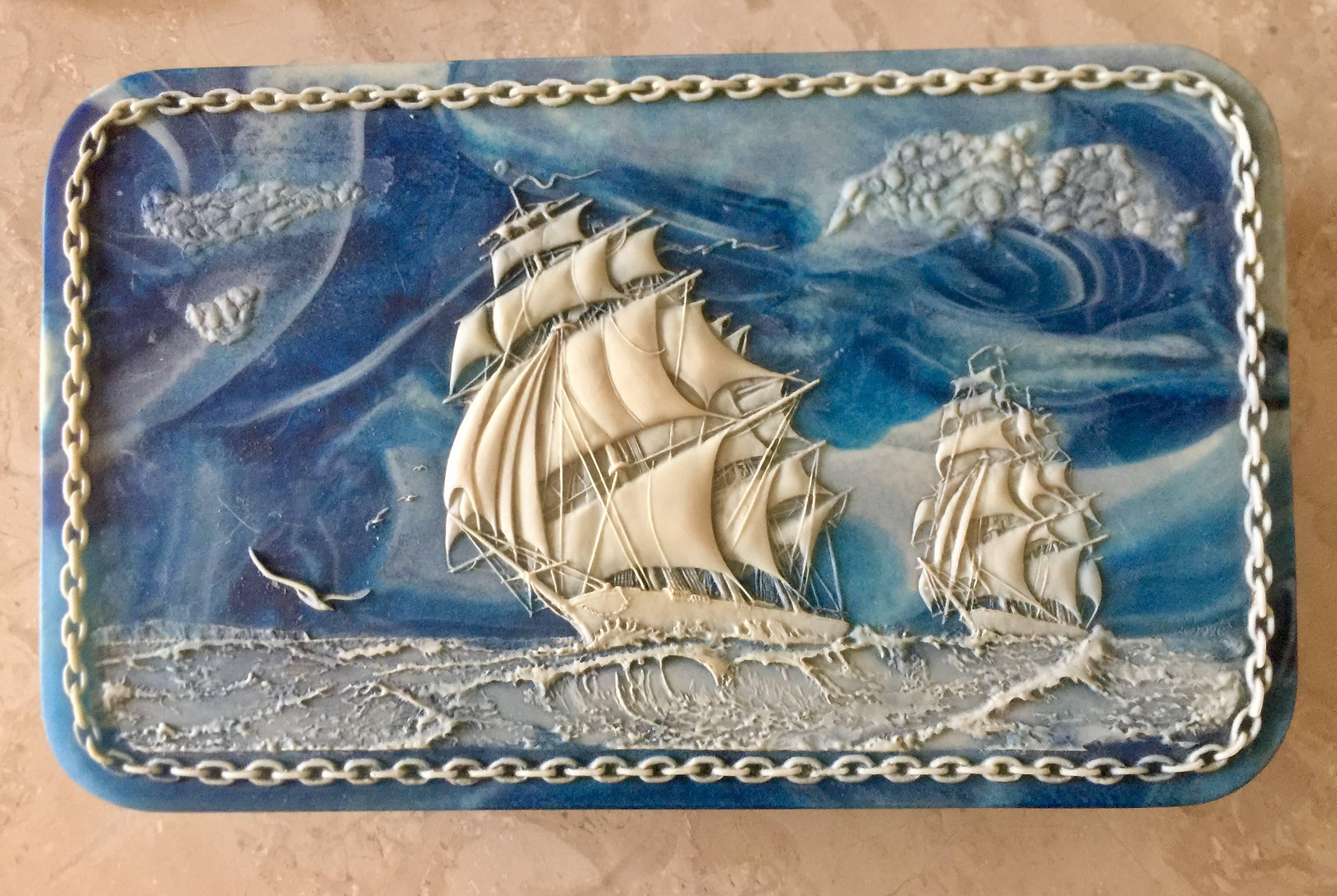 Super incolay vintage hinged box featuring sailing ships all the way around. Really a stunning piece and vintage. Measures 13 x 3 x 7"

Incolay stone is a complex combination of quart based minerals such as rose quartz, sapphire blue,