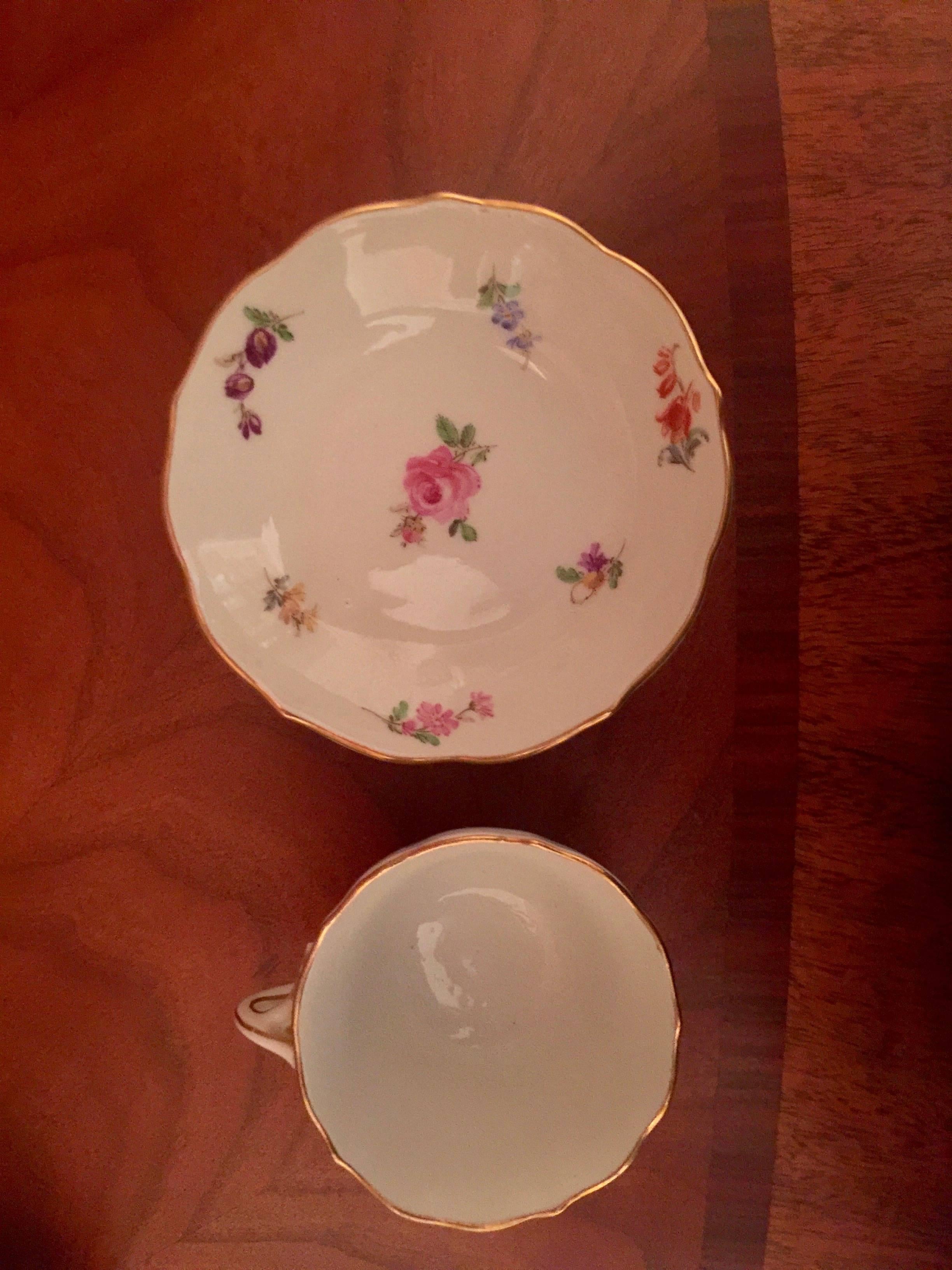 19th century vintage German Meissen demitasse cup and saucer
with a scattering of tiny flowers, each with twisted handles and the blue crossed swords mark to the underside.
Measures: Cup 1.75